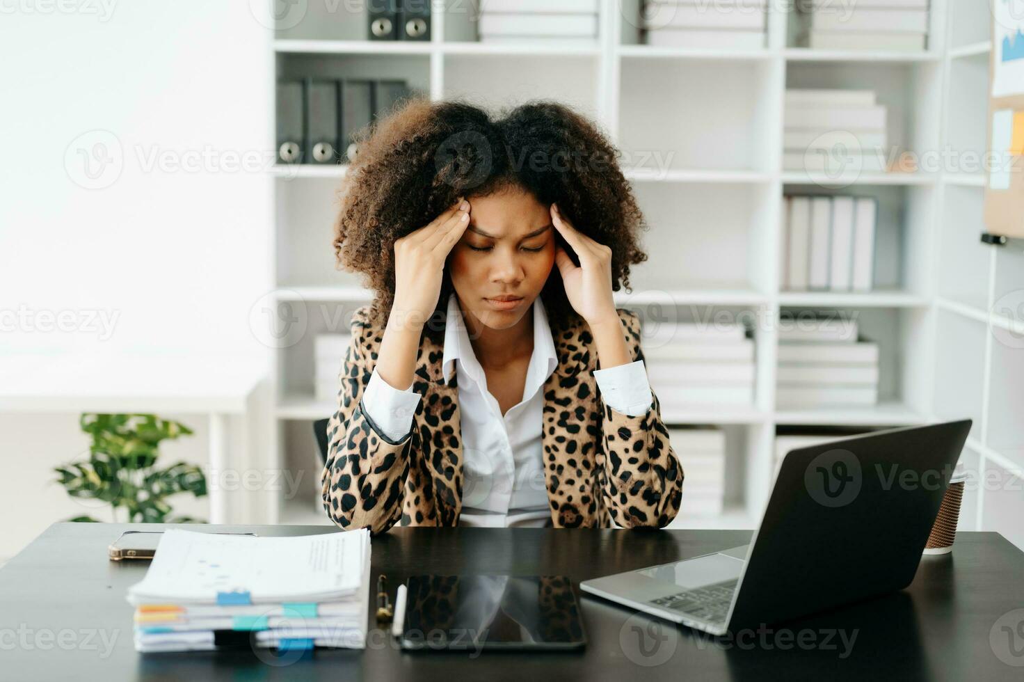 African Woman who is tired and overthinking from working with tablet and laptop at office. photo