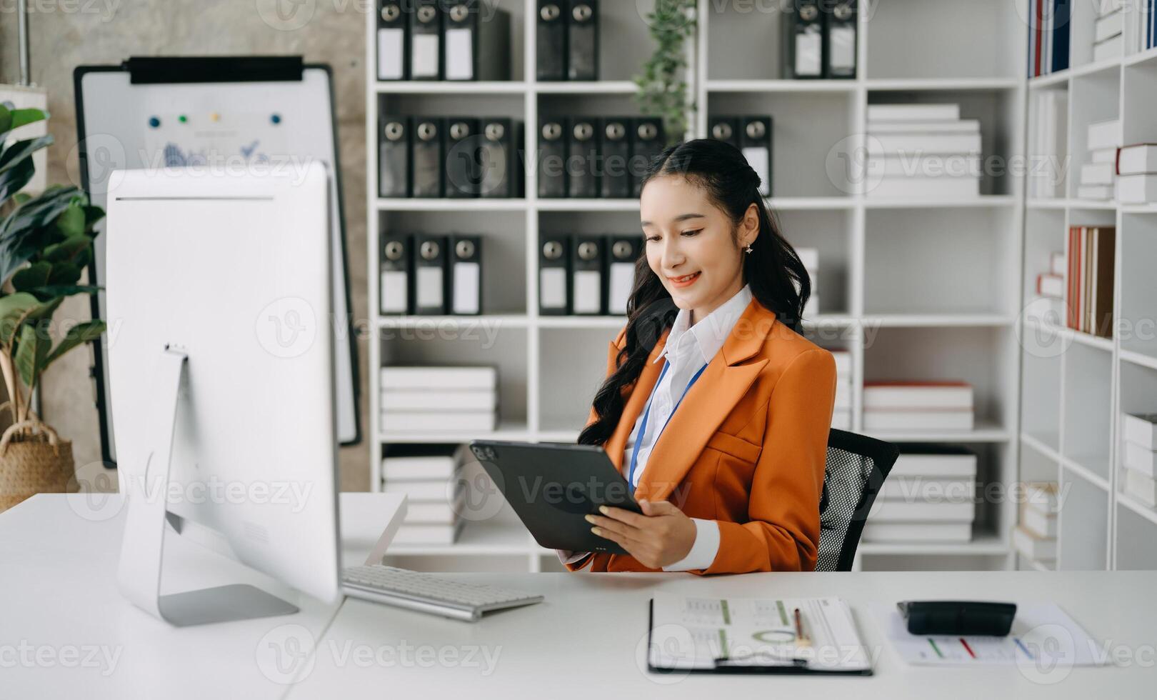 Business woman using tablet and laptop for doing math finance on an office desk, tax, report, accounting, statistics, and analytical research concept in office photo