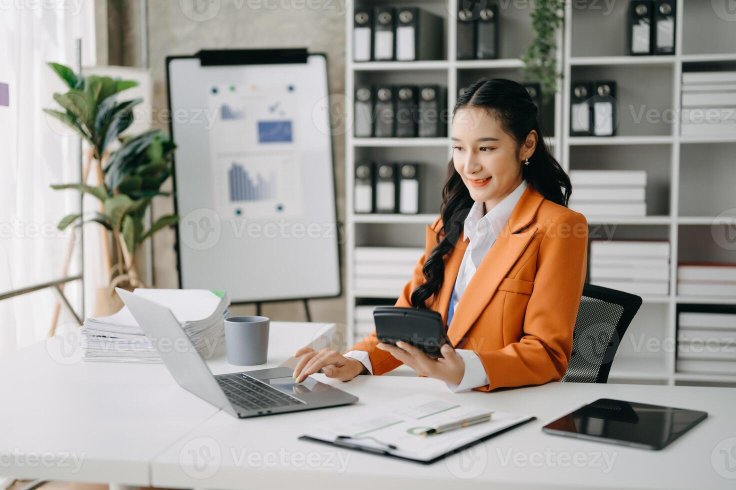 Business woman using tablet and laptop for doing math finance on an office desk, tax, report, accounting, statistics, and analytical research concept in office photo