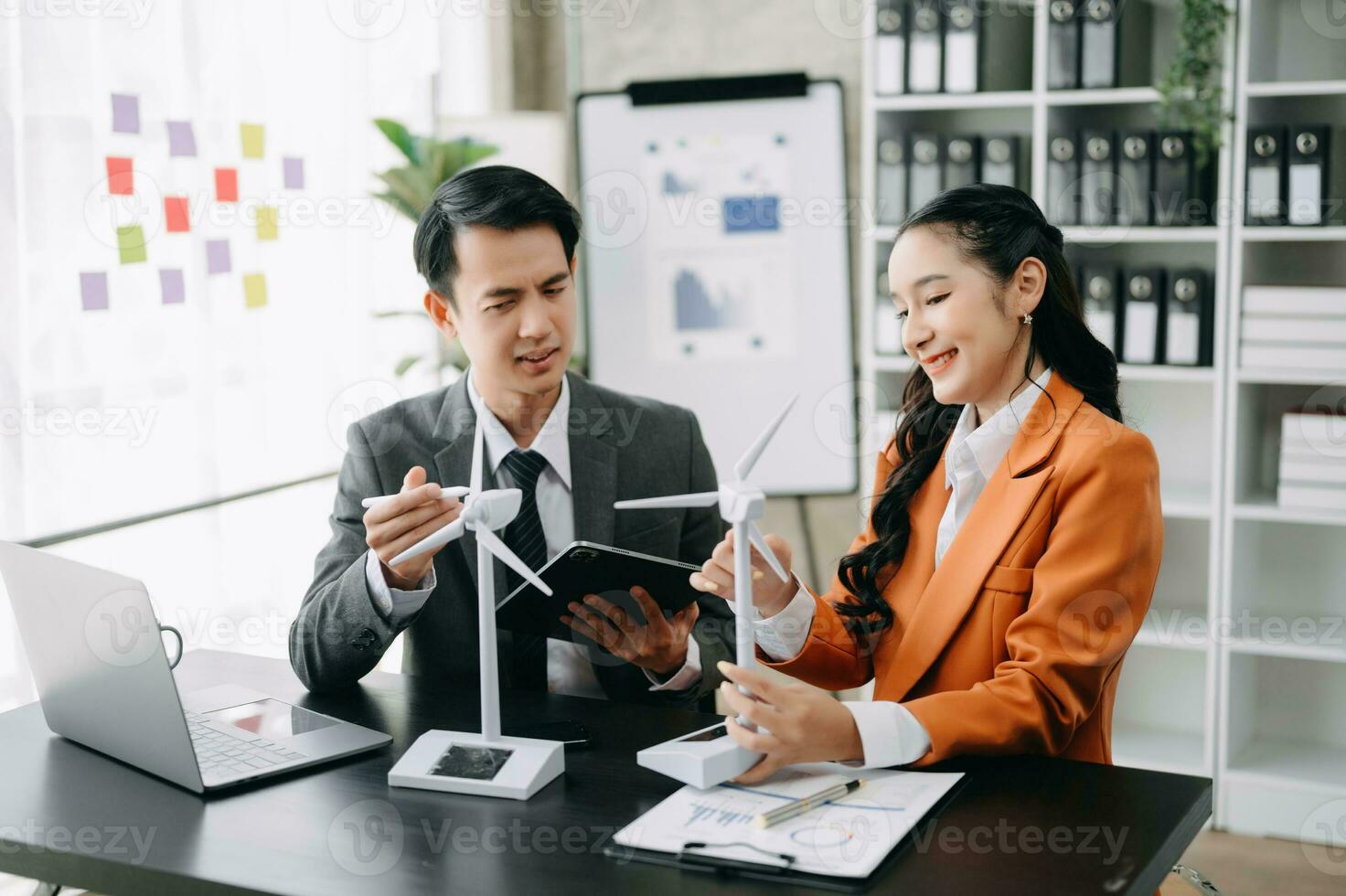 Alternative energy engineer pointing to a solar power panel and discuss with  business colleague team for the future power in the office photo