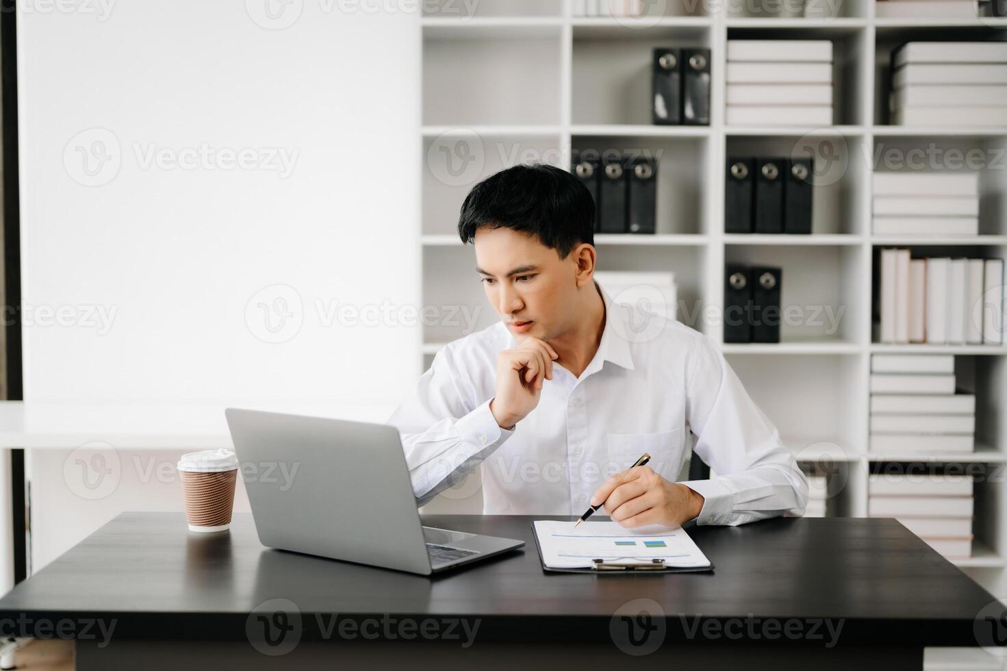 Businessman using tablet and laptop for doing math finance on an office desk, tax, report, accounting, statistics, and analytical research concept in office photo