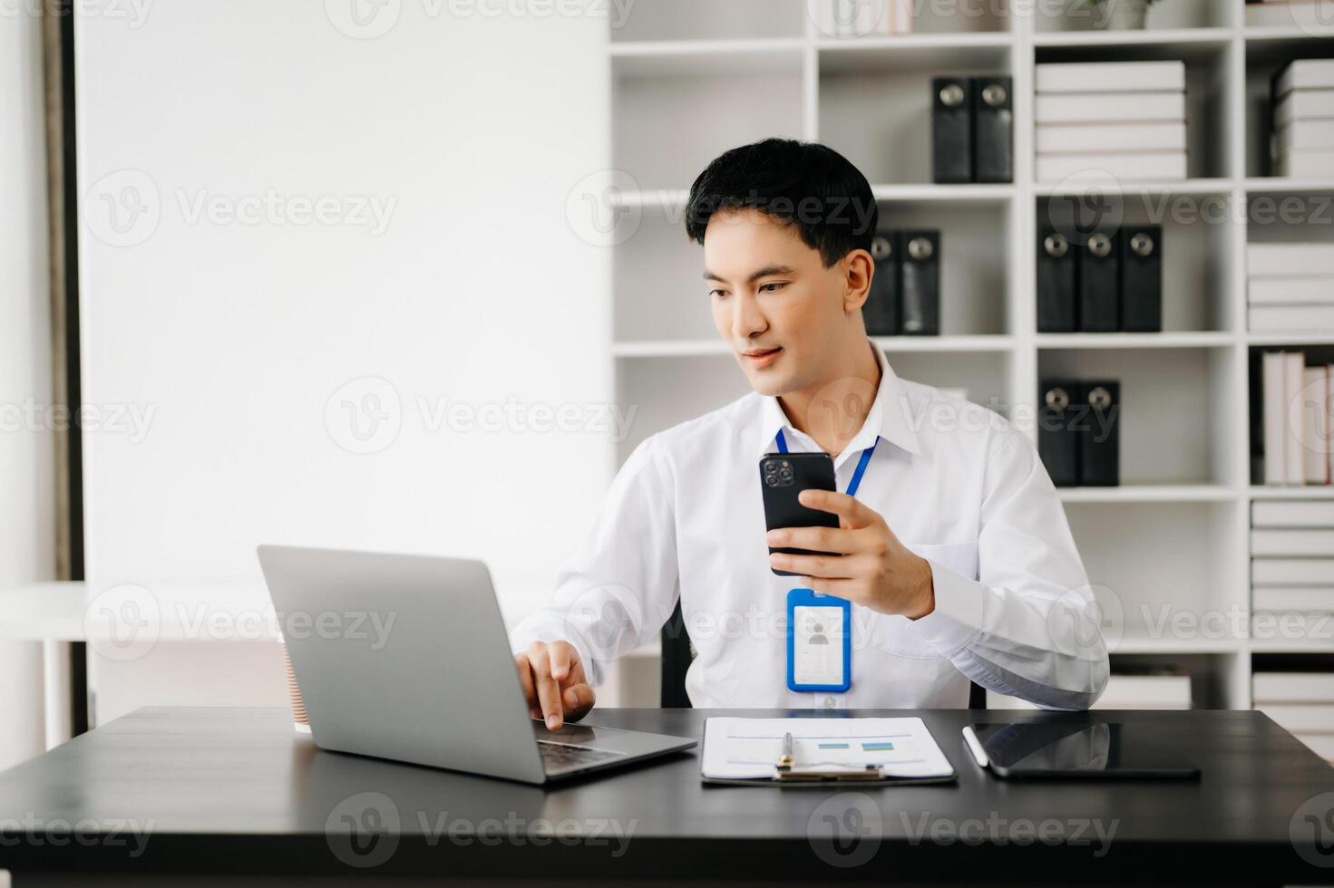 Businessman using tablet and laptop for doing math finance on an office desk, tax, report, accounting, statistics, and analytical research concept in office photo
