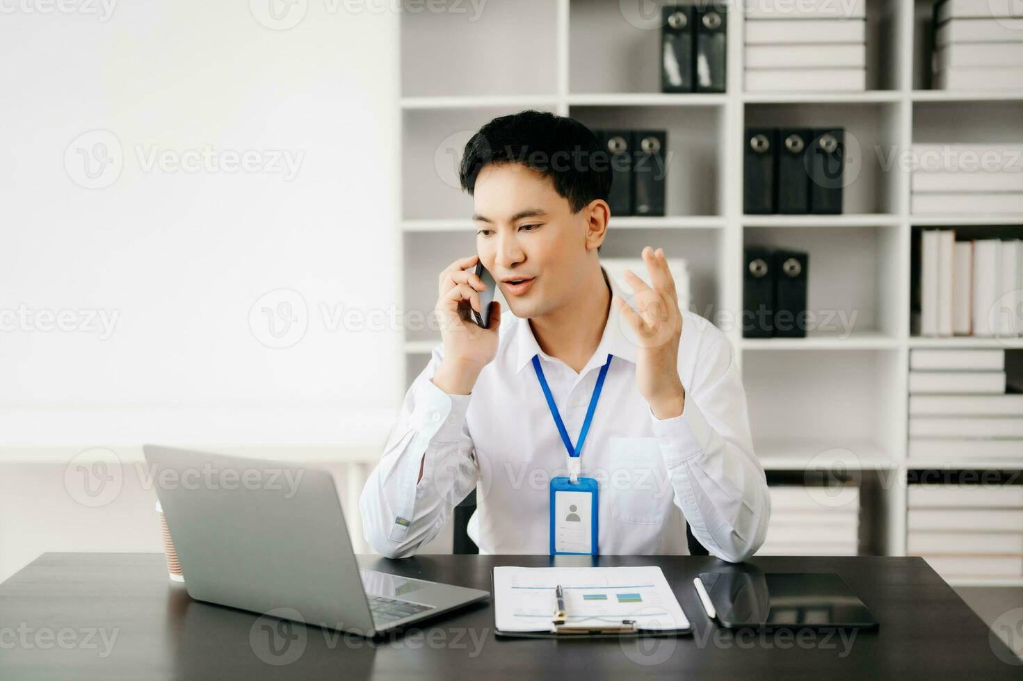Happy asian businessman have the joy of talking on the smartphone, tablet and laptopon the office photo