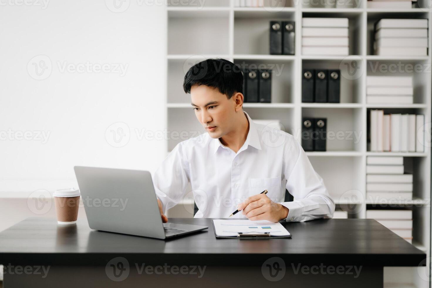 Businessman using tablet and laptop for doing math finance on an office desk, tax, report, accounting, statistics, and analytical research concept in office photo