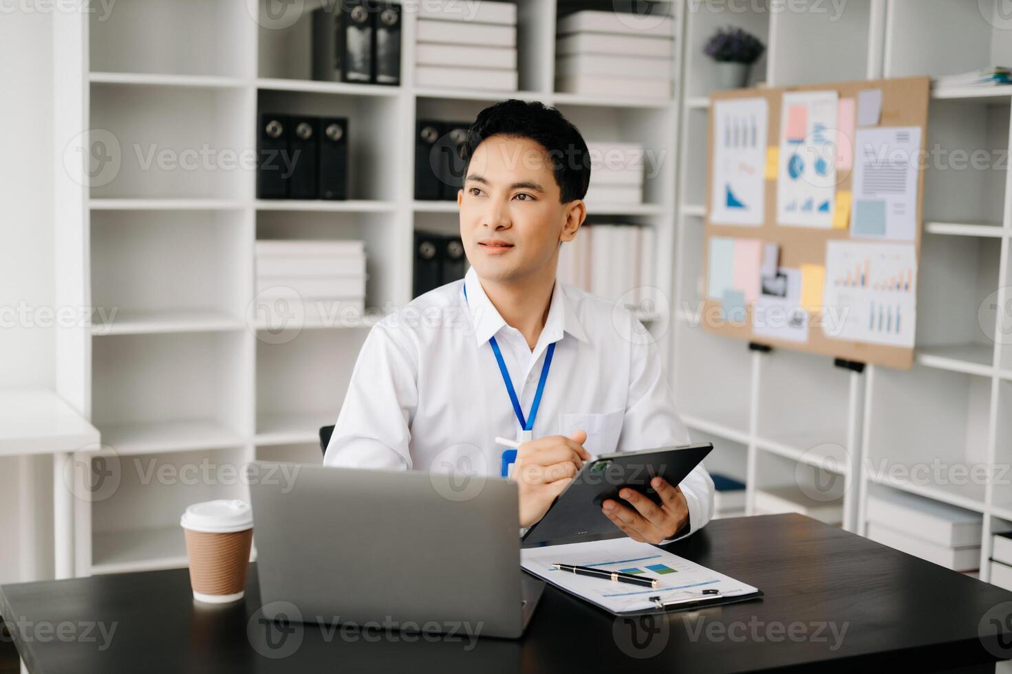 Businessman using tablet and laptop for doing math finance on an office desk, tax, report, accounting, statistics, and analytical research concept in office photo