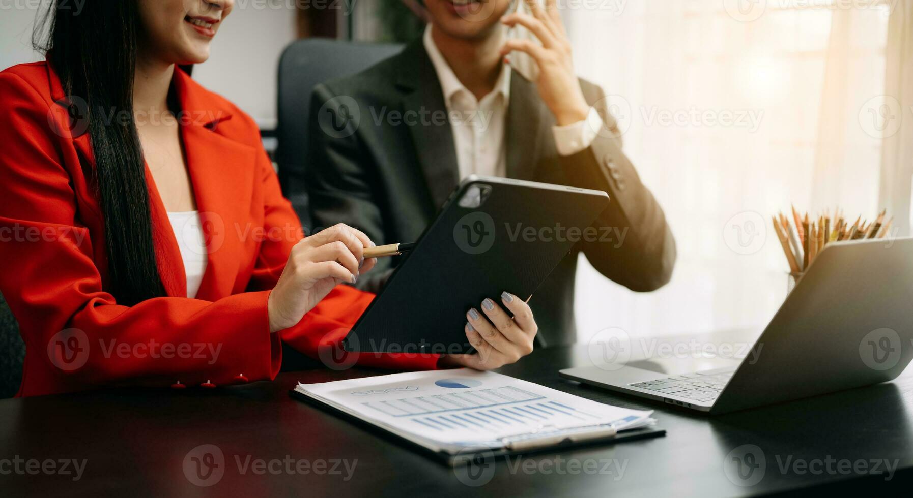 Business documents on office table with smart phone and calculator digital tablet and graph business with social network diagram and two colleagues discussing data working in the office photo