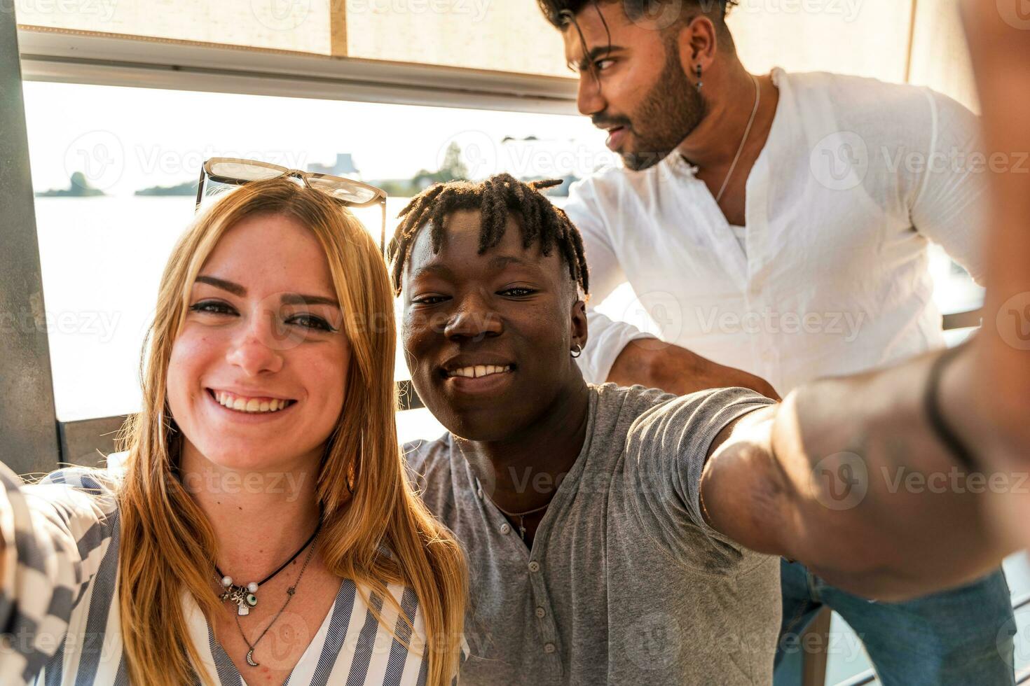 pequeño grupo de multiétnico amigos teniendo divertido tomando un selfie con teléfono inteligente foto