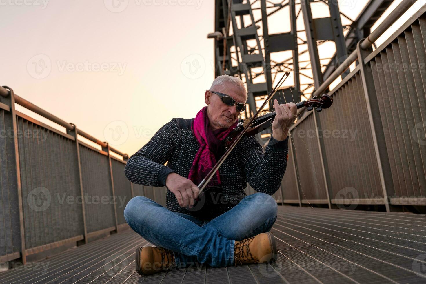 atractivo medio Envejecido músico hombre jugando un eléctrico violín al aire libre foto