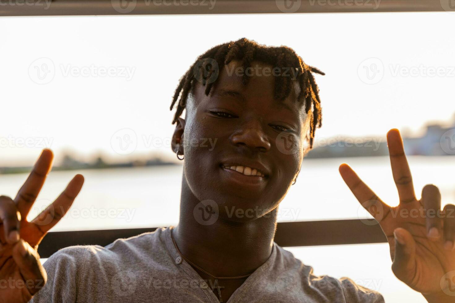 portrait of young handsome african american man sitting on boat sailing during summer vacation photo