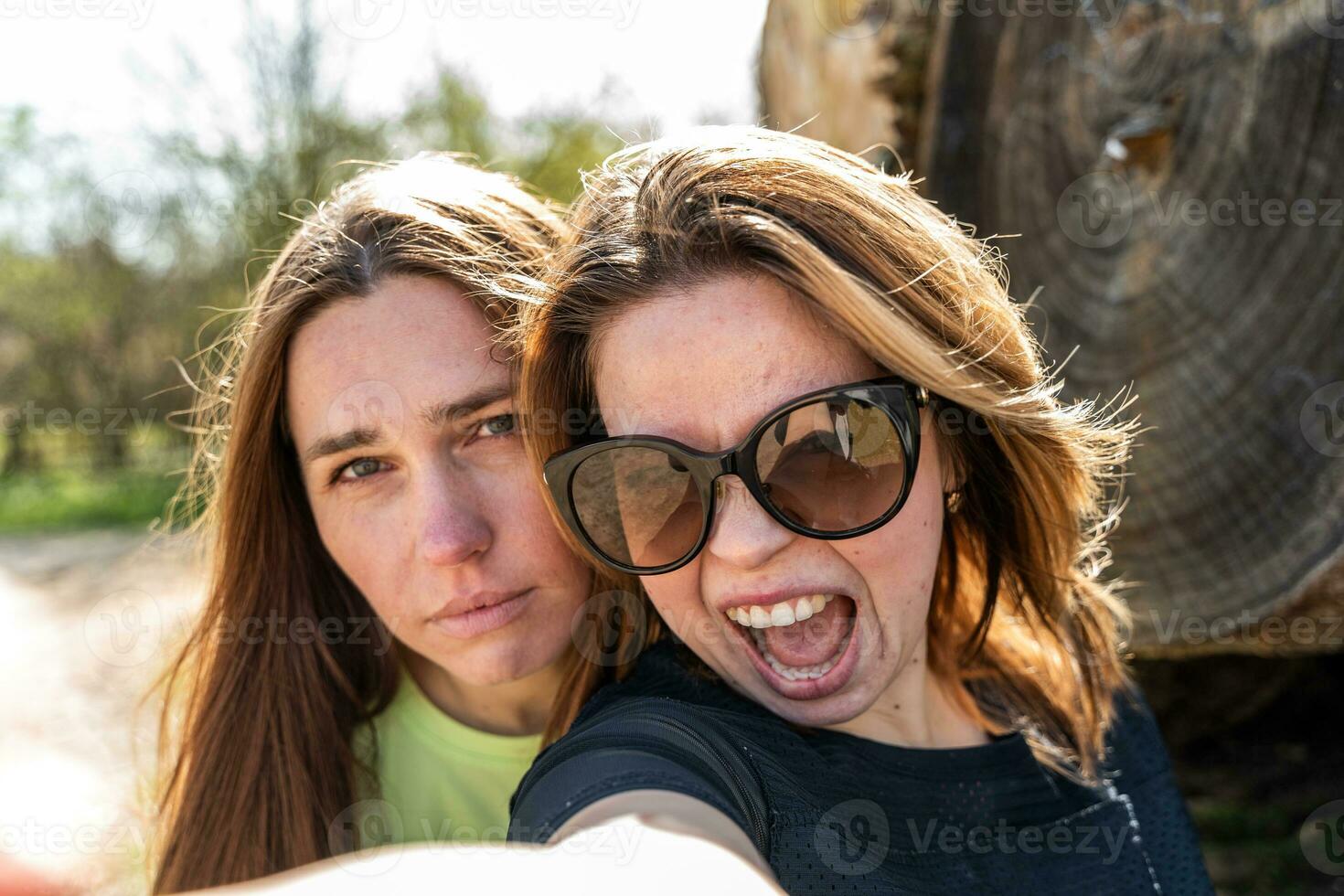 Pareja de bonito simpático mujer tomando un selfie haciendo gracioso caras foto