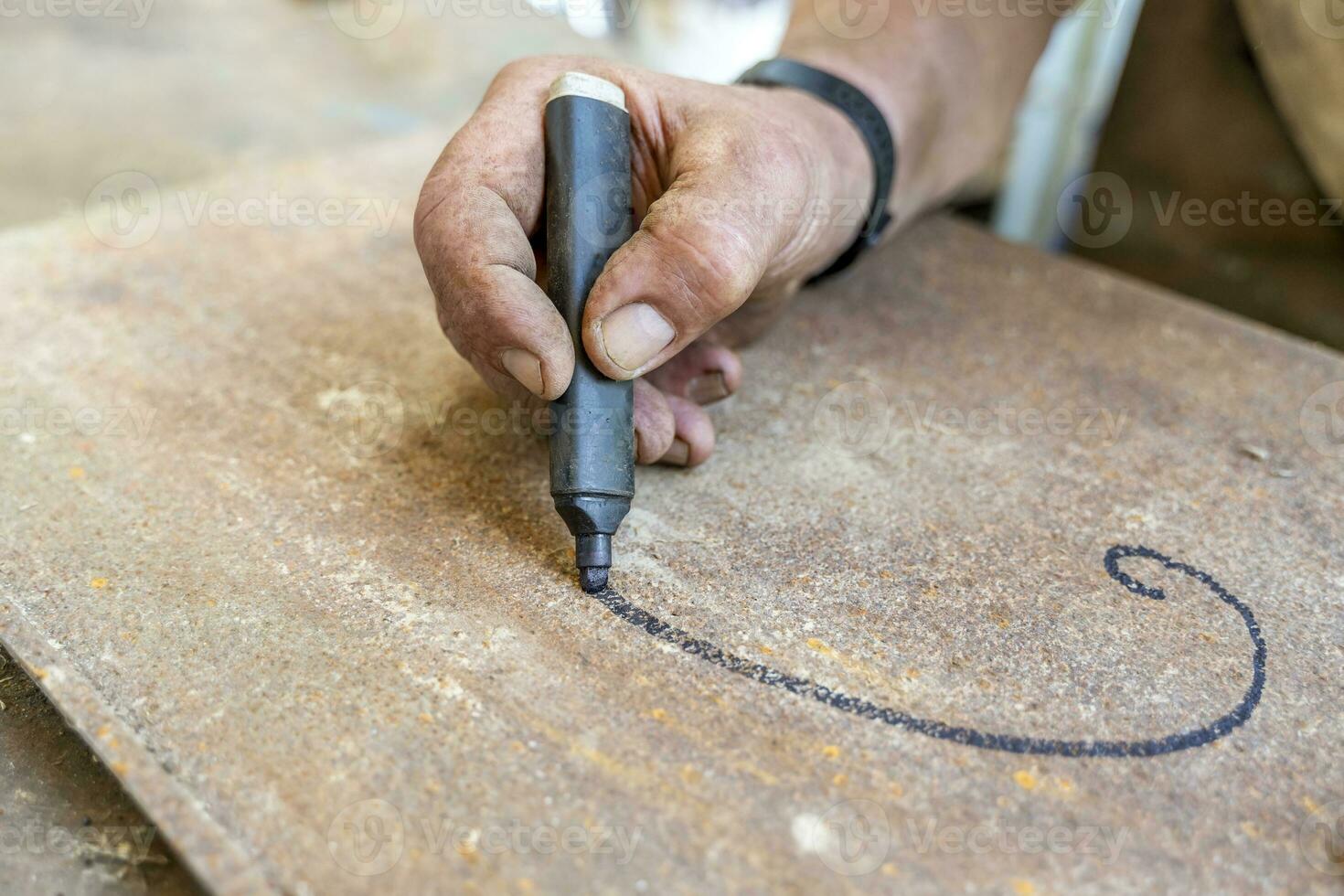 close-up of hand is writing with a black marker on a metal panel photo