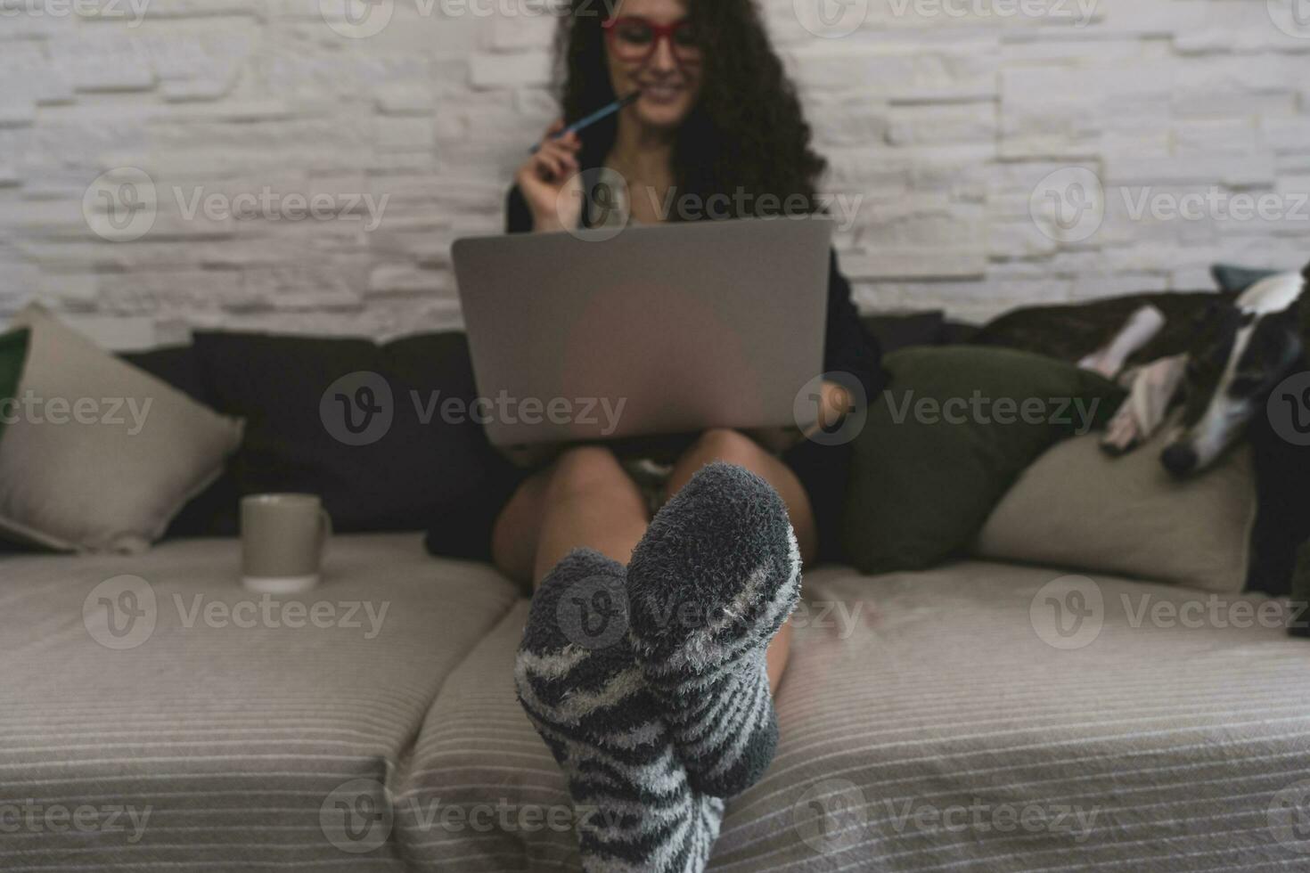 young woman takes a relaxing moment on sofa while working from home on