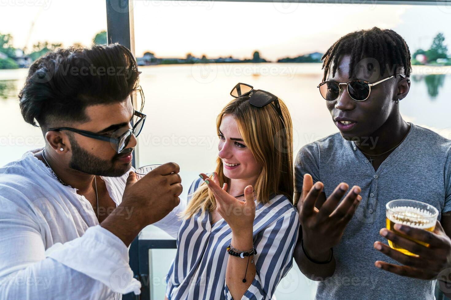 pequeño grupo de joven adulto multiétnico amigos celebrando tostado con alcohol foto