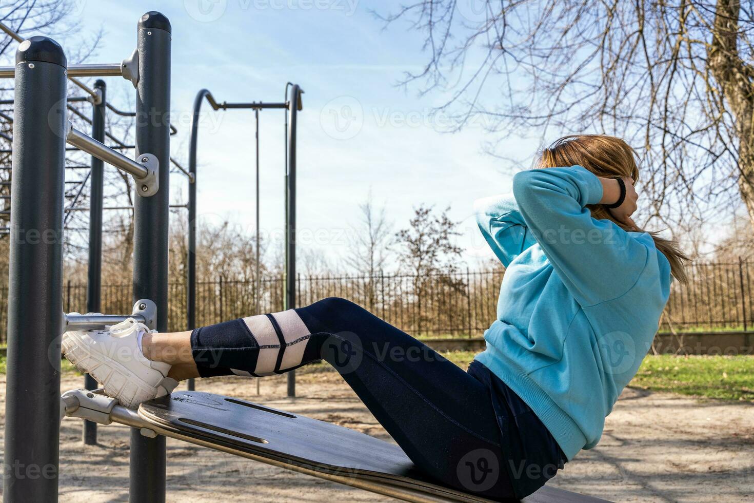 retrato de joven mujer haciendo abdominal músculos rutina de ejercicio en un banco al aire libre foto