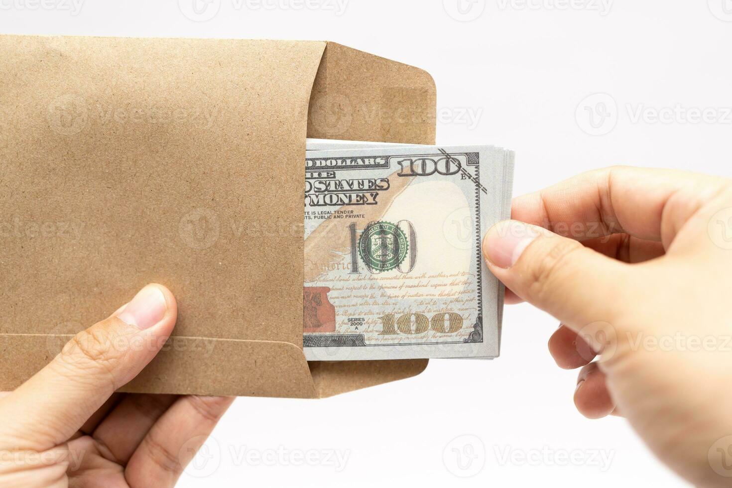 Hands holding open craft paper envelope with hundred dollars on isolated background with copy space. photo