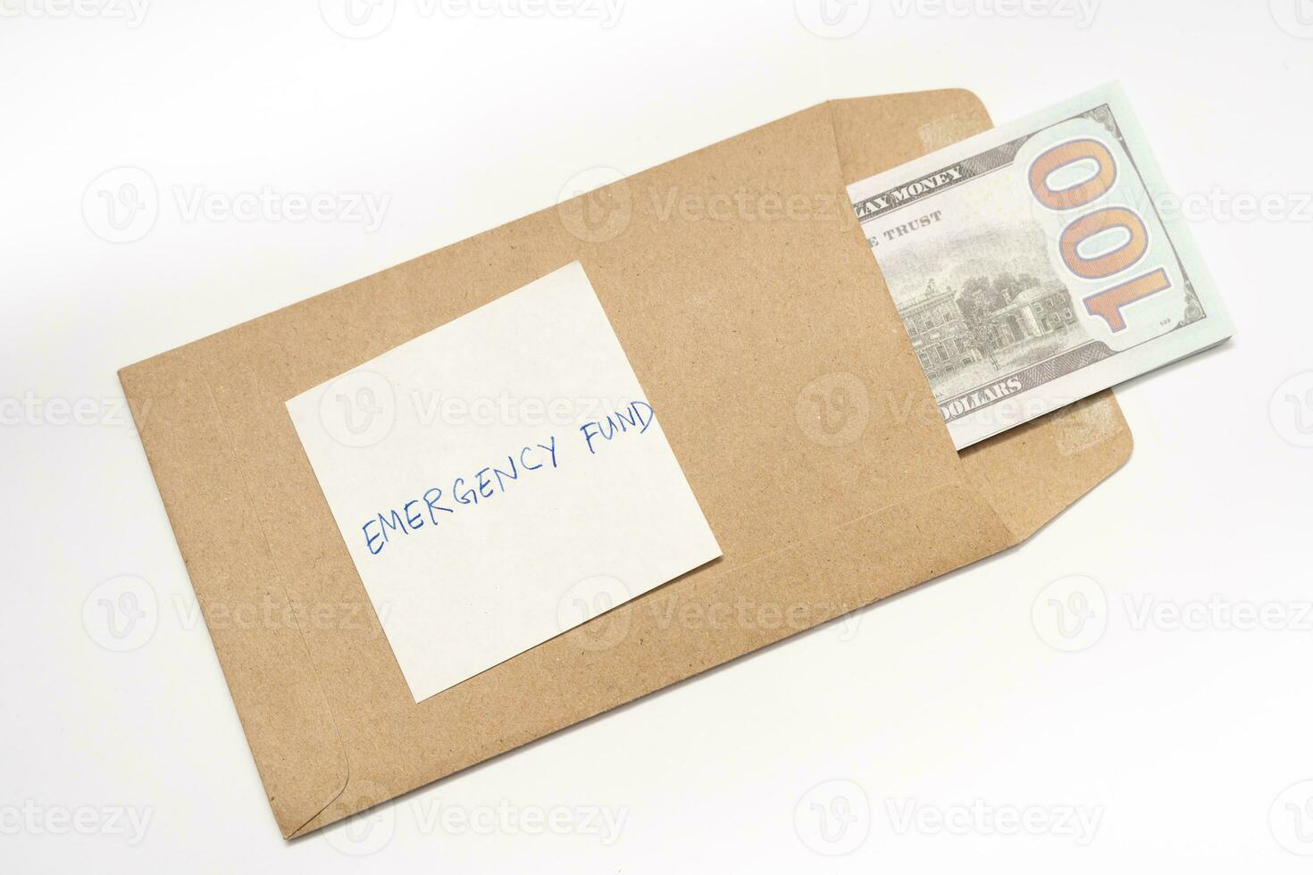 Dollars cash money in craft paper envelope and paper note with text written EMERGENCY FUND. concept of financial planning saving money goal on purpose of rainy day. photo