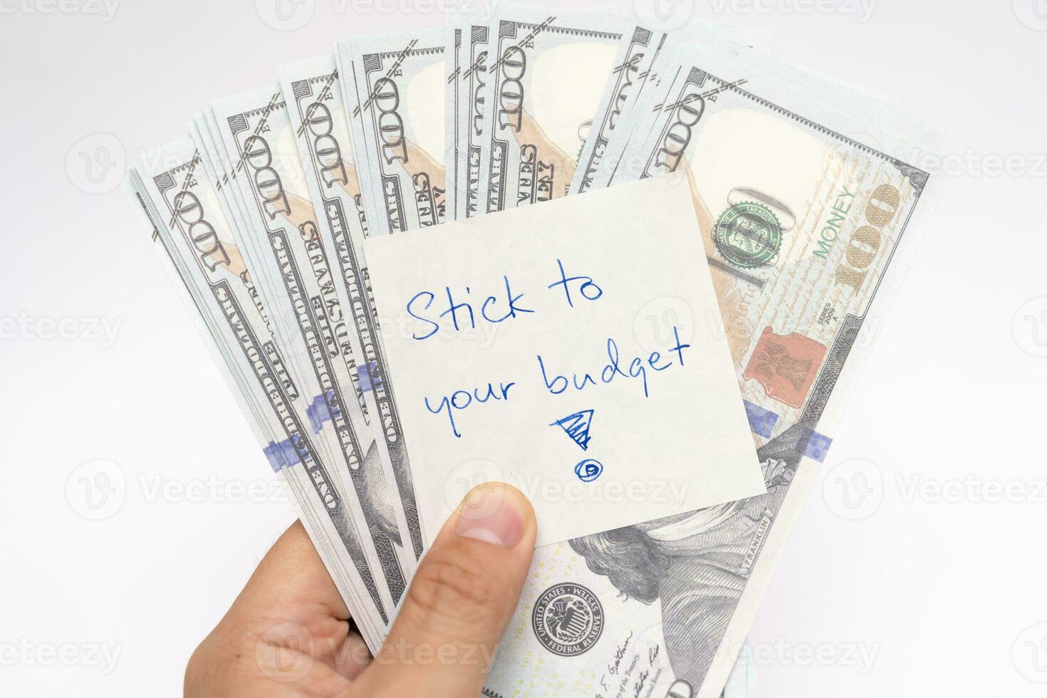 Dollars cash money with text written note STICK TO YOUR BUDGET. concept of financial planning to save money by spending less. Finance and business concept. photo