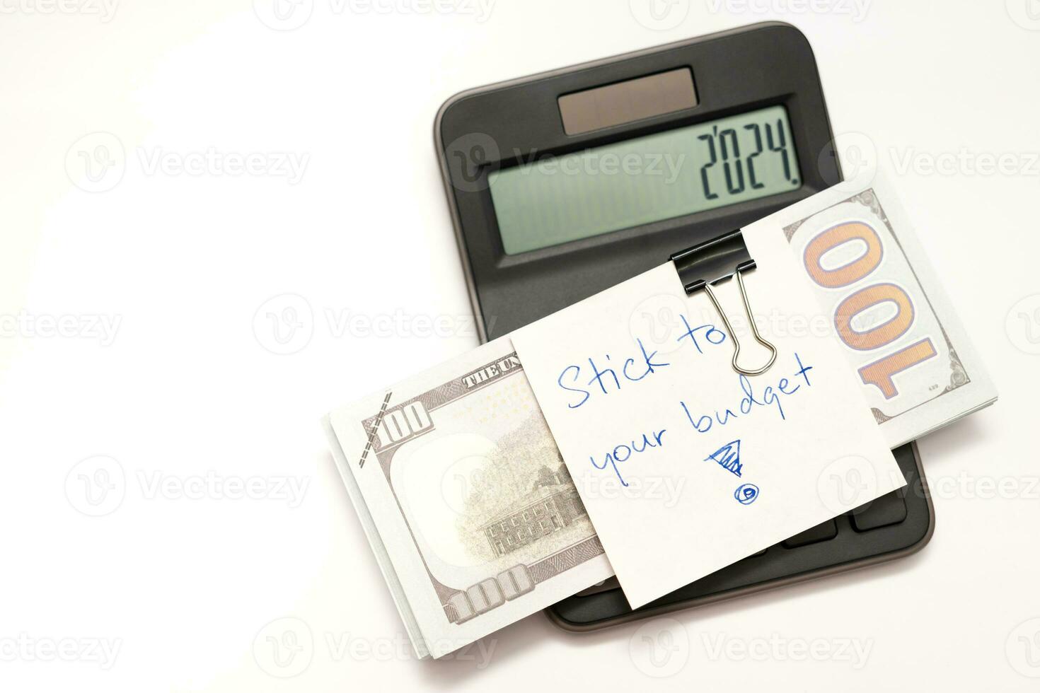 Dollars cash money with text written note STICK TO YOUR BUDGET. concept of financial planning to save money by spending less. Finance and business concept. photo