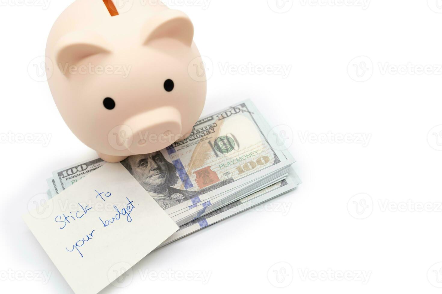 Text written note STICK TO YOUR BUDGET and Piggy bank on US Dollars. concept of financial planning to save money by spending less. Finance and business concept. isolated background. photo