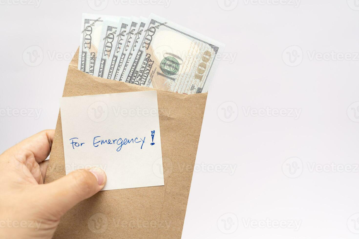 Dollars cash money in craft paper envelope and paper note with text written FOR EMERGENCY. concept of financial planning saving money goal on purpose of rainy day. photo