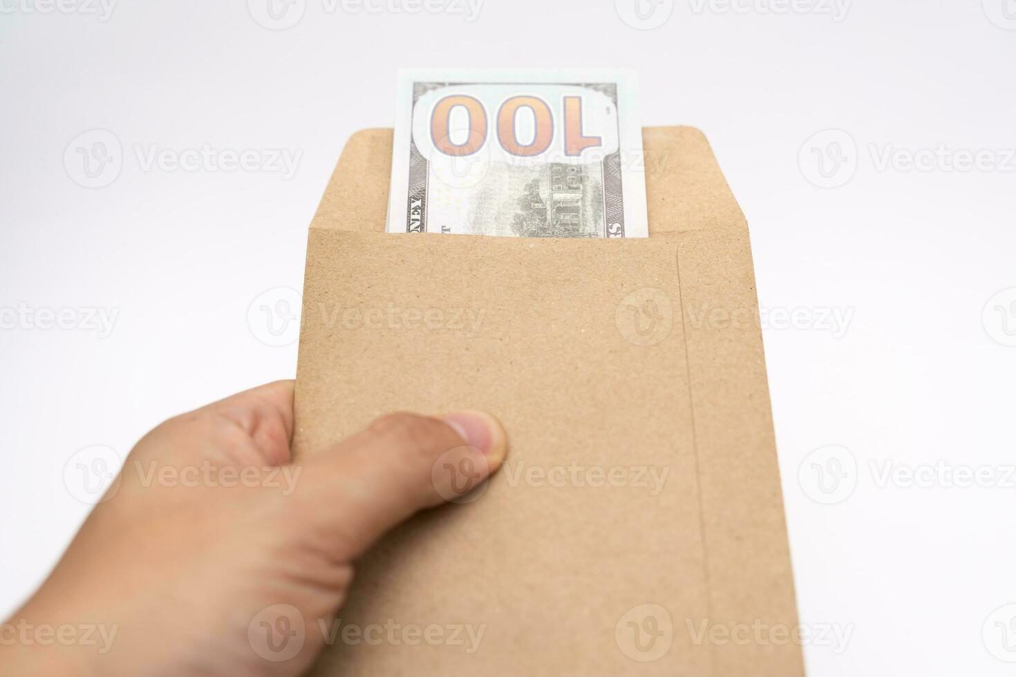 Hands holding open craft paper envelope with hundred dollars on isolated background with copy space. photo
