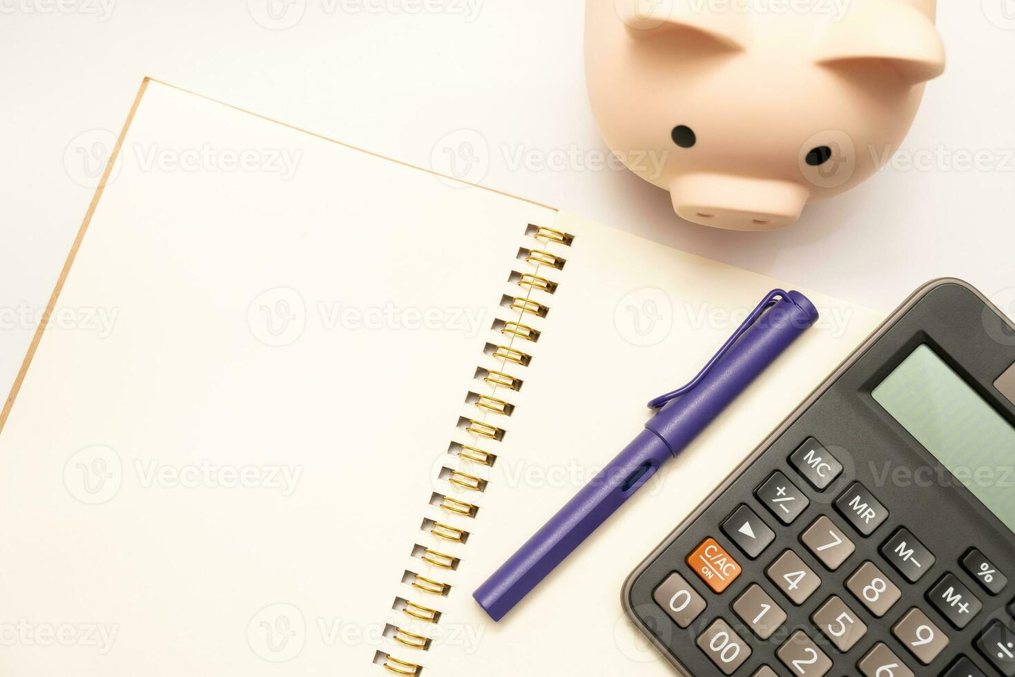 Piggy bank with calculator and notebooks on white background and copy space, financial goal concept. photo
