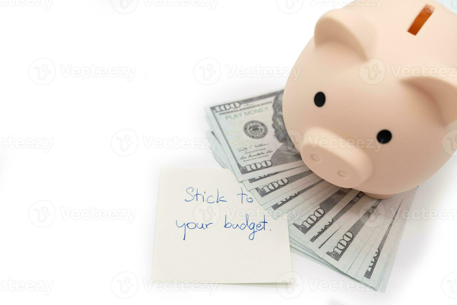 Text written note STICK TO YOUR BUDGET and Piggy bank on US Dollars. concept of financial planning to save money by spending less. Finance and business concept. isolated background. photo