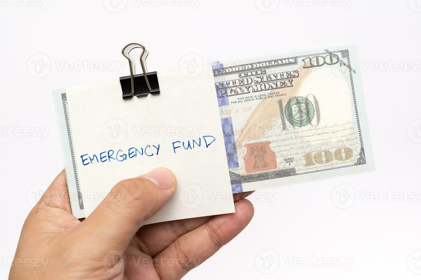 US dollars in paper clip on white background with note written EMERGENCY FUND. Concept of money saving goal. Financial planning saving money for purpose of rainy day crisis. photo