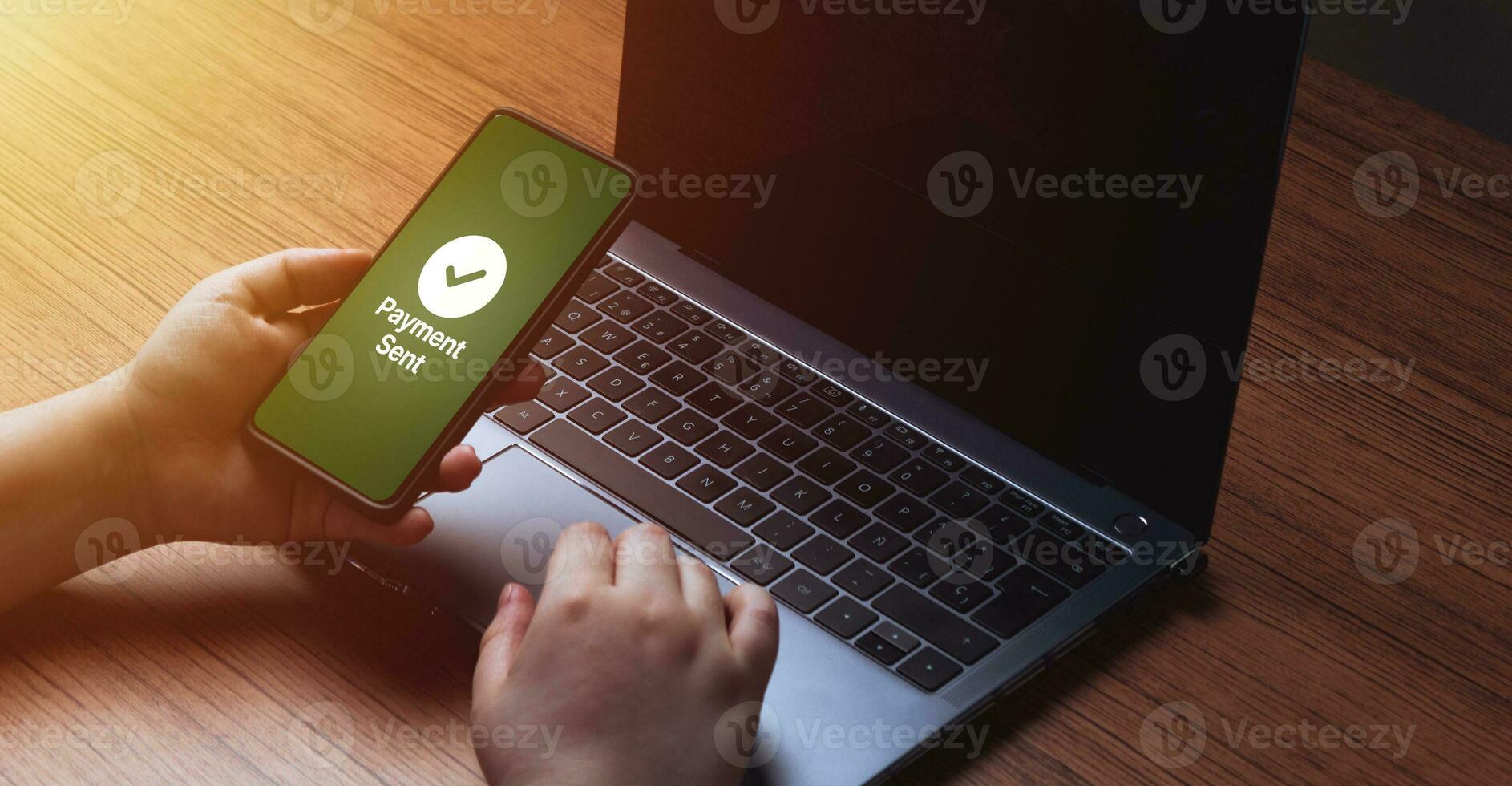 Woman use smartphone for a financial transaction. Mobile with message of payment sent on screen. Concept of financial transactions with mobile devices. Office desk. Money sent transfer. Shopping. photo