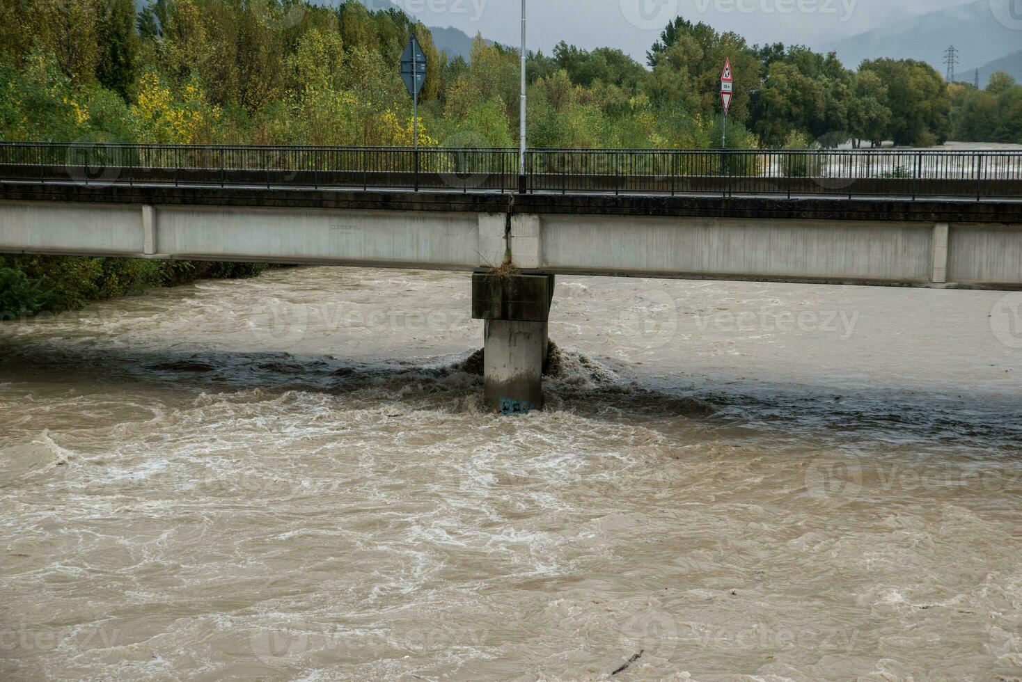 Flood of a river after a period of heavy rain. Water level near to the bridge photo