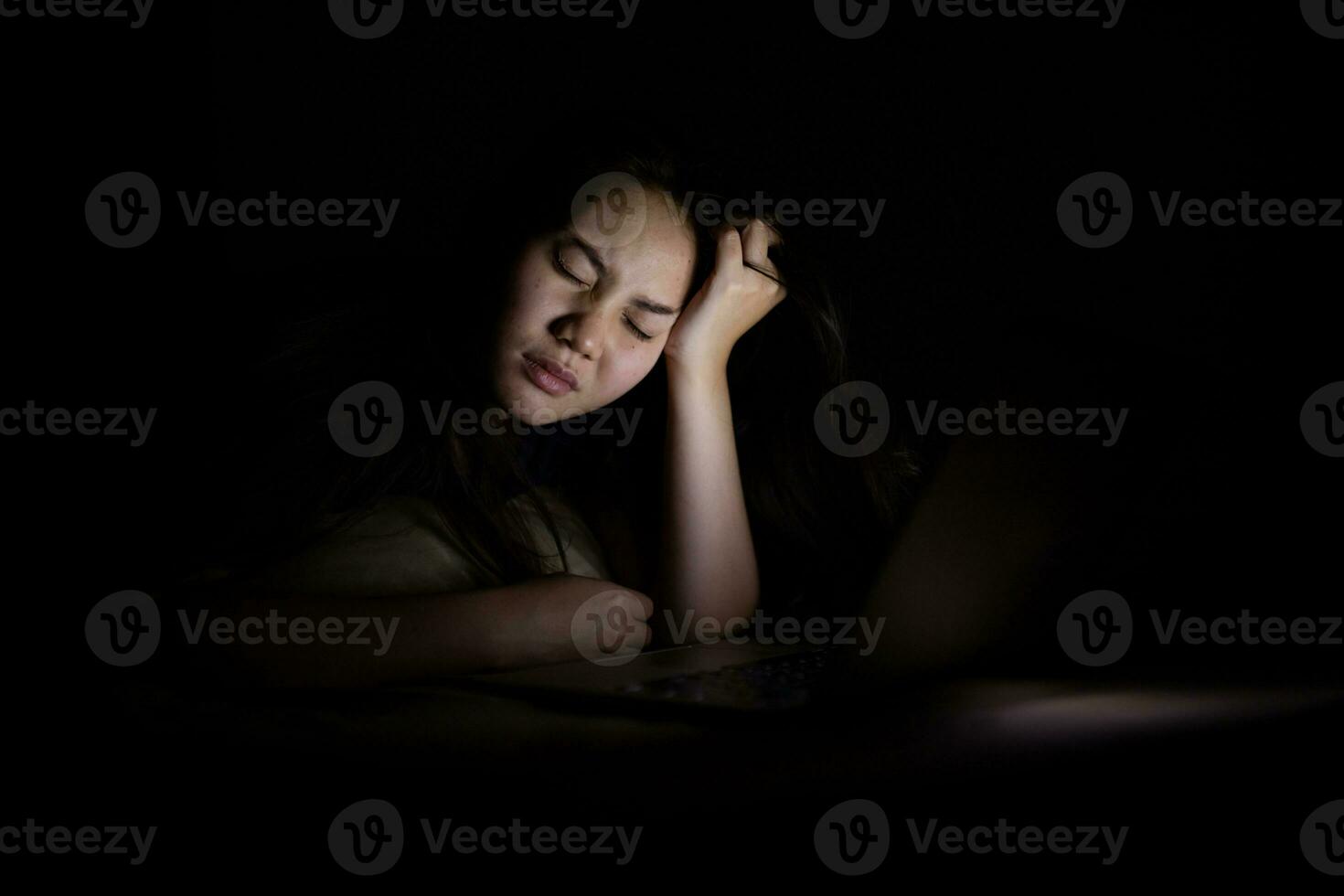 Young asian women work late at night stressed out. Tired and exhausted from working on computer laptop in the bedroom. photo