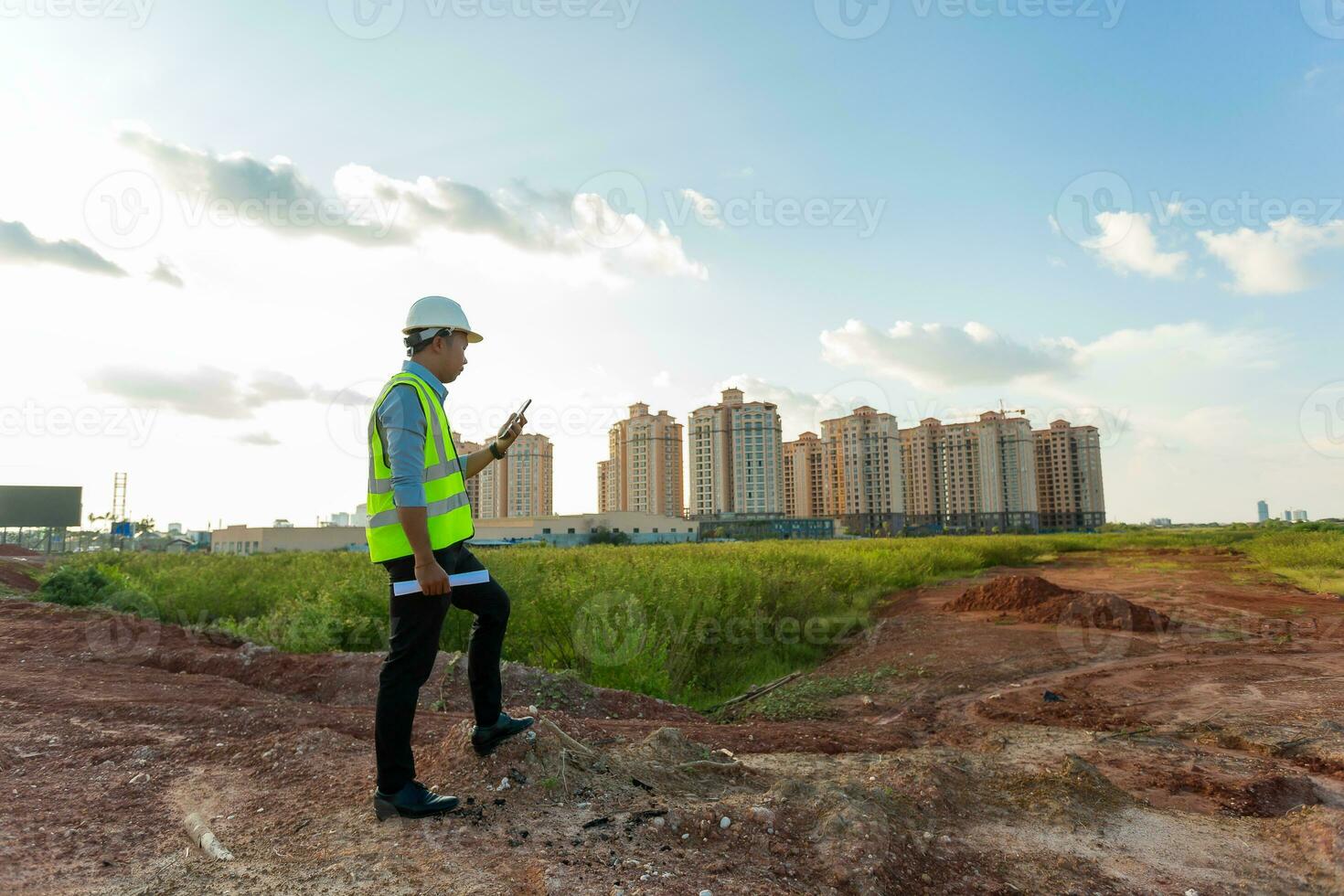 Engineer male use smartphone for working or checking at construction building site photo