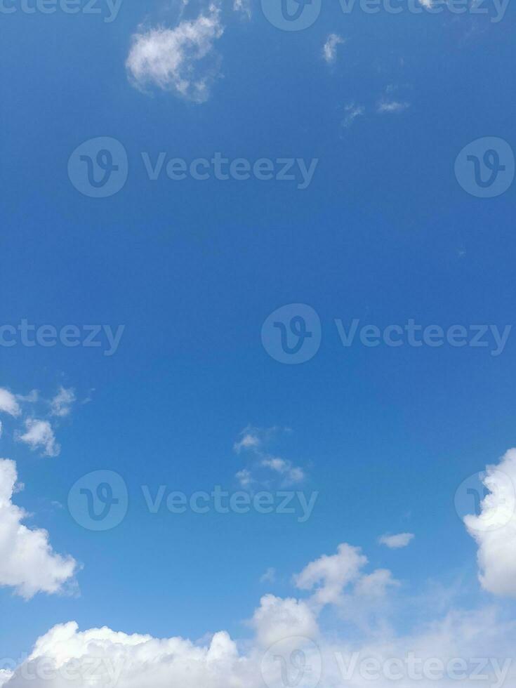 White clouds in the blue sky. Beautiful bright blue background. Light cloudy, good weather. Curly clouds on a sunny day. photo