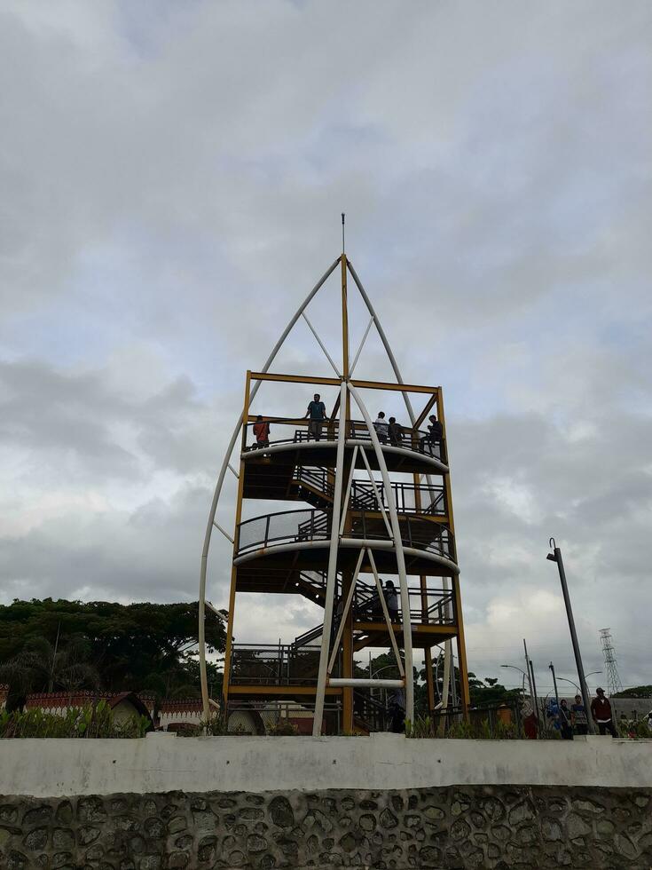 March 5, 2023 - Yellow tower ladder in the shore, Loang Baloq Beach, Mataram, Lombok island, Indonesia. Visitors, max. 10 people, can go upstair to enjoy and see the beach's view from atop photo