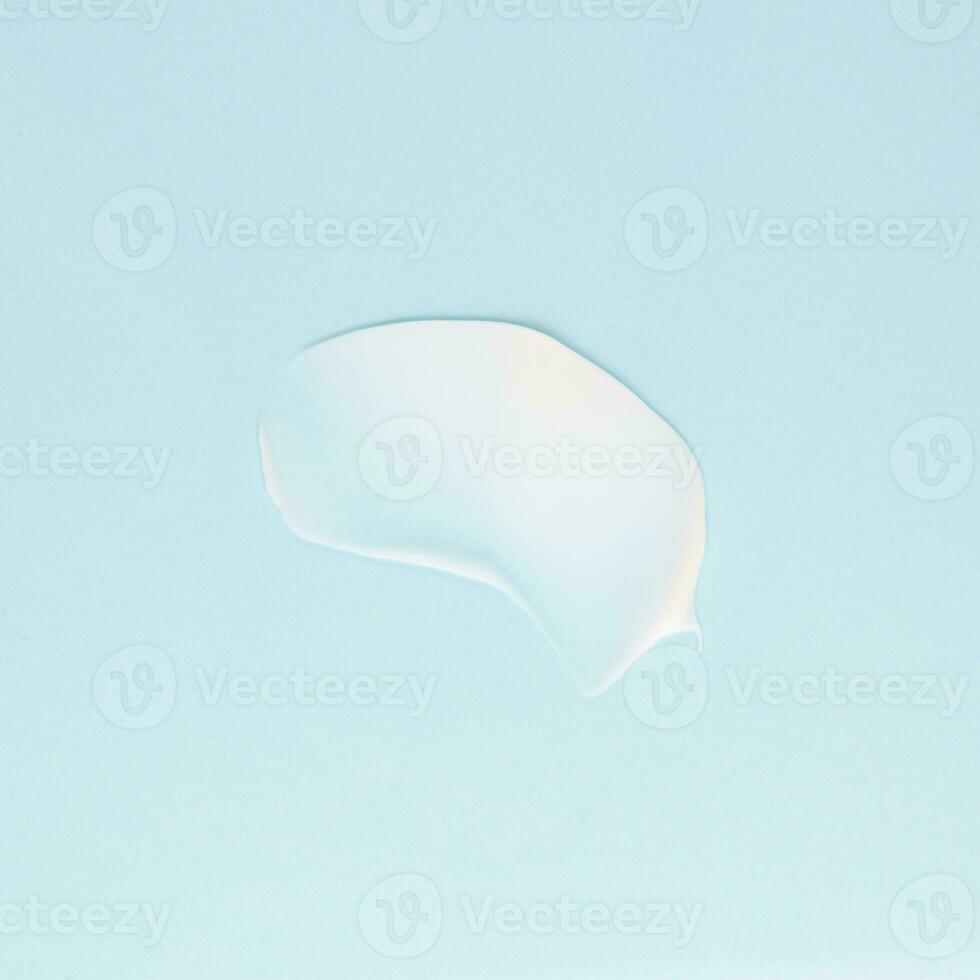 Smear of white cream for face and body on a blue background photo