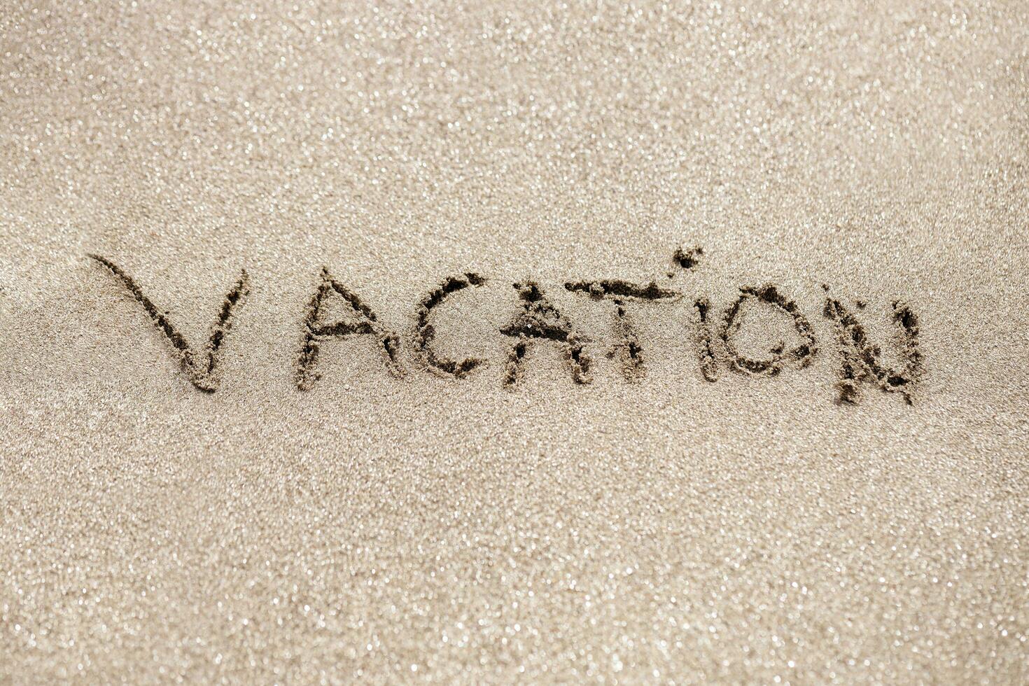 Word vacation written on the sand photo
