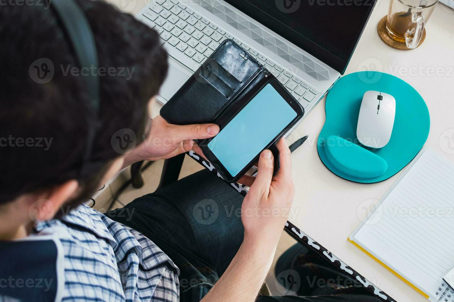 Top view of entrepreneur checking his mobile phone, in front of work desk. photo