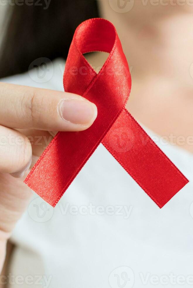 World Aids Day, hand with red ribbon symbol photo