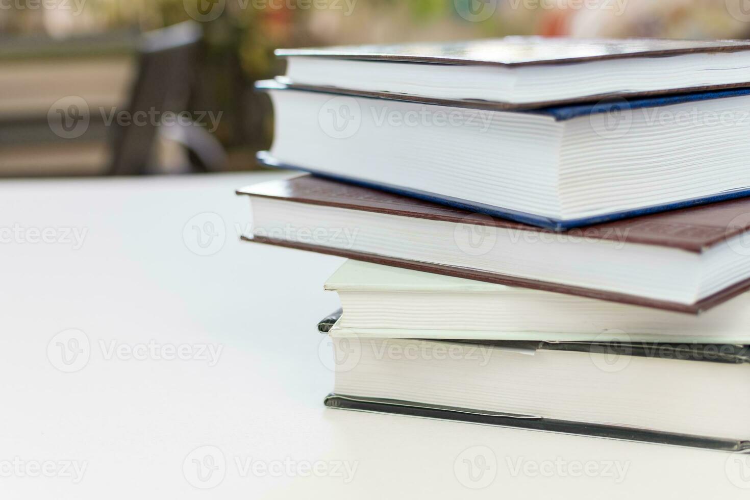 Desk with stack of study books. Textbooks for the student, university. Study from home. Distance education concept. photo