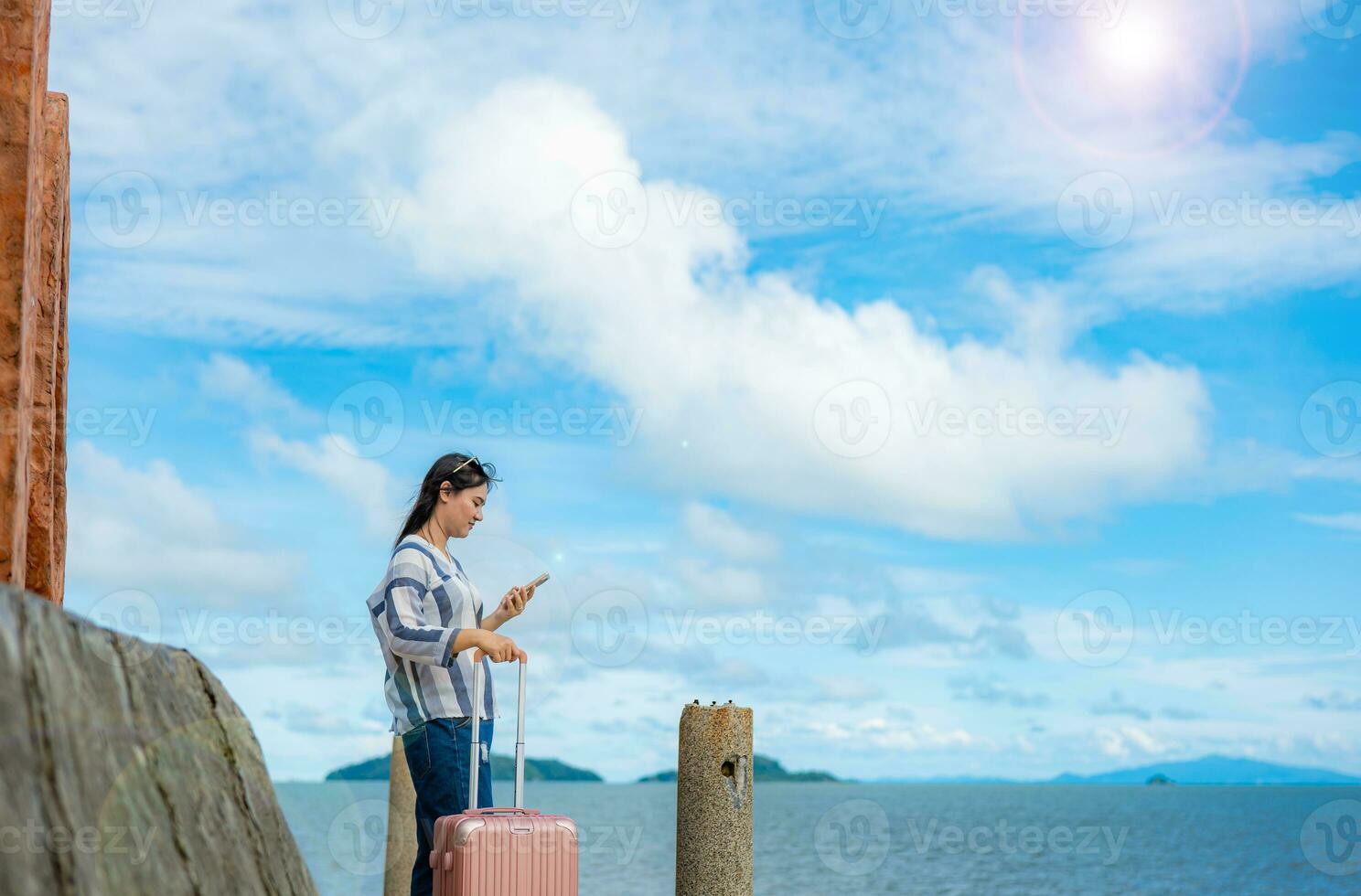 woman with her suitcase luggage on beautiful  sea view on sunny day joy nature, sea, back view photo