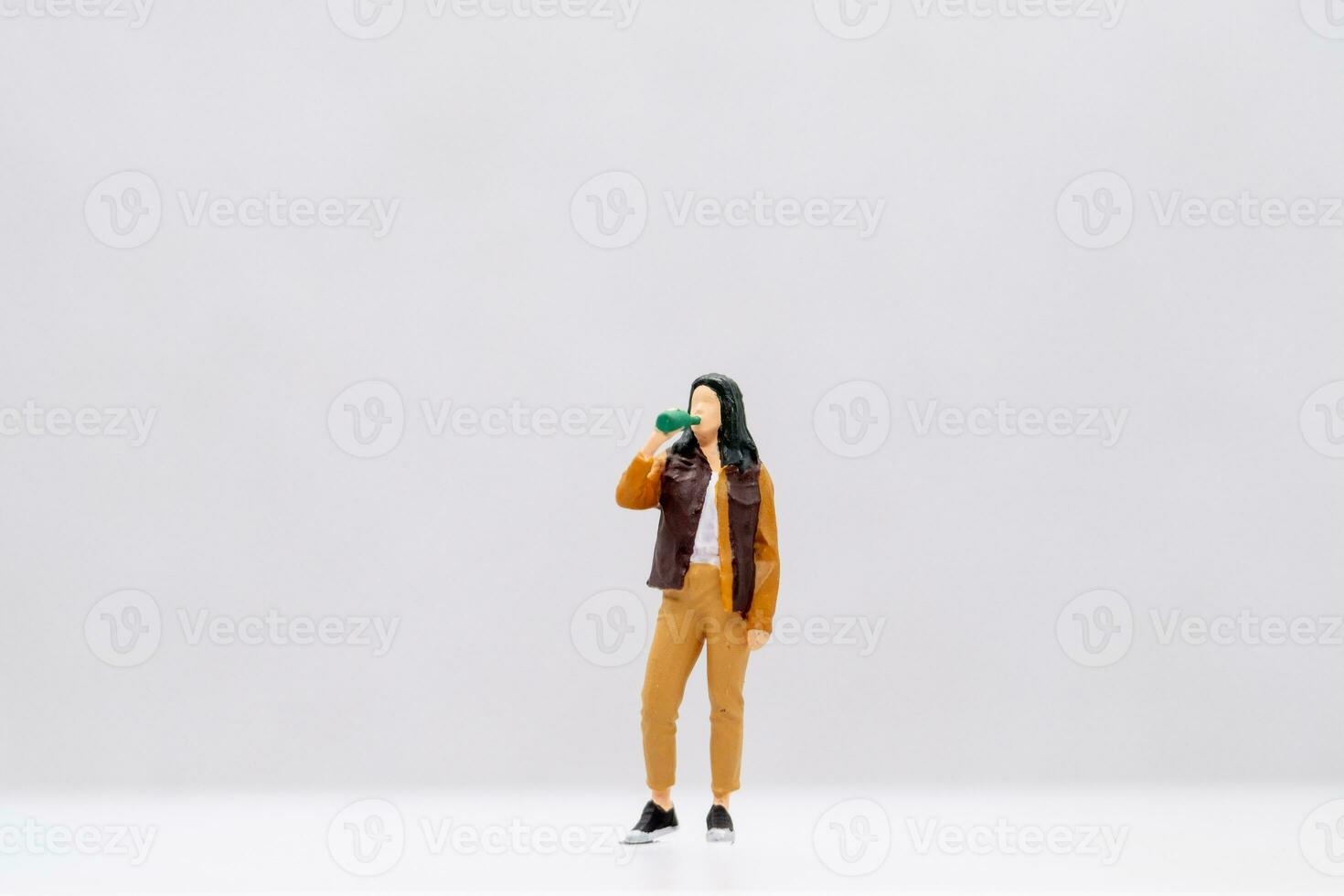 Miniature people Young woman drinking water from bottle photo