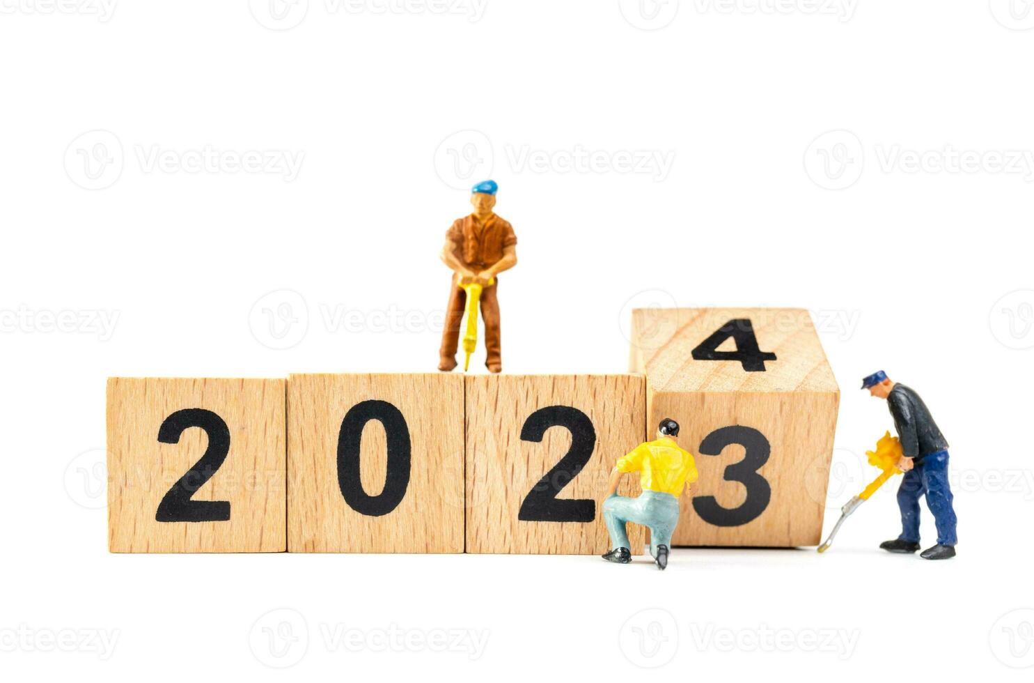 Miniature people , Worker team flips a wooden block with the number 2024 photo