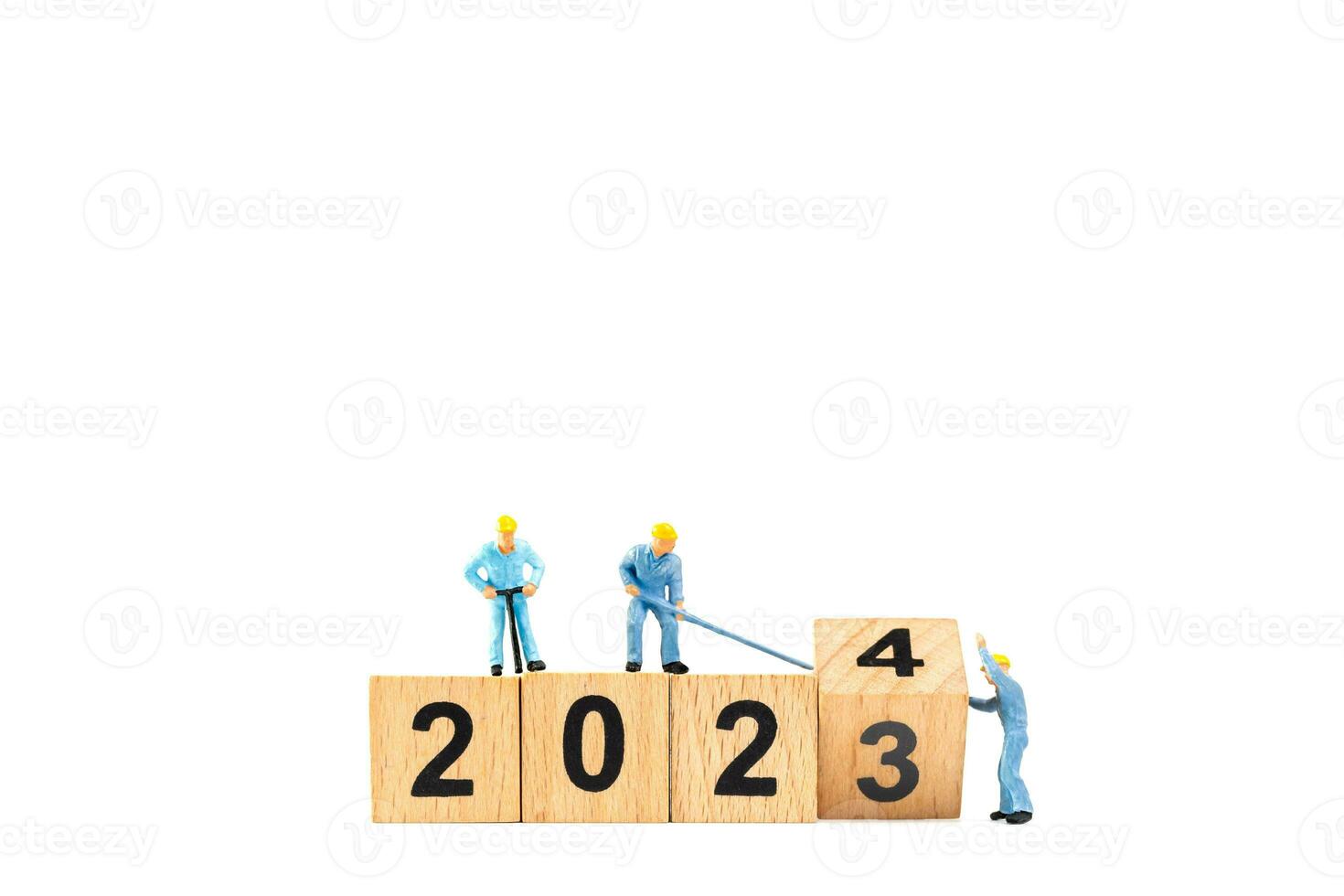 Miniature people , Worker team flips a wooden block with the number 2024 photo