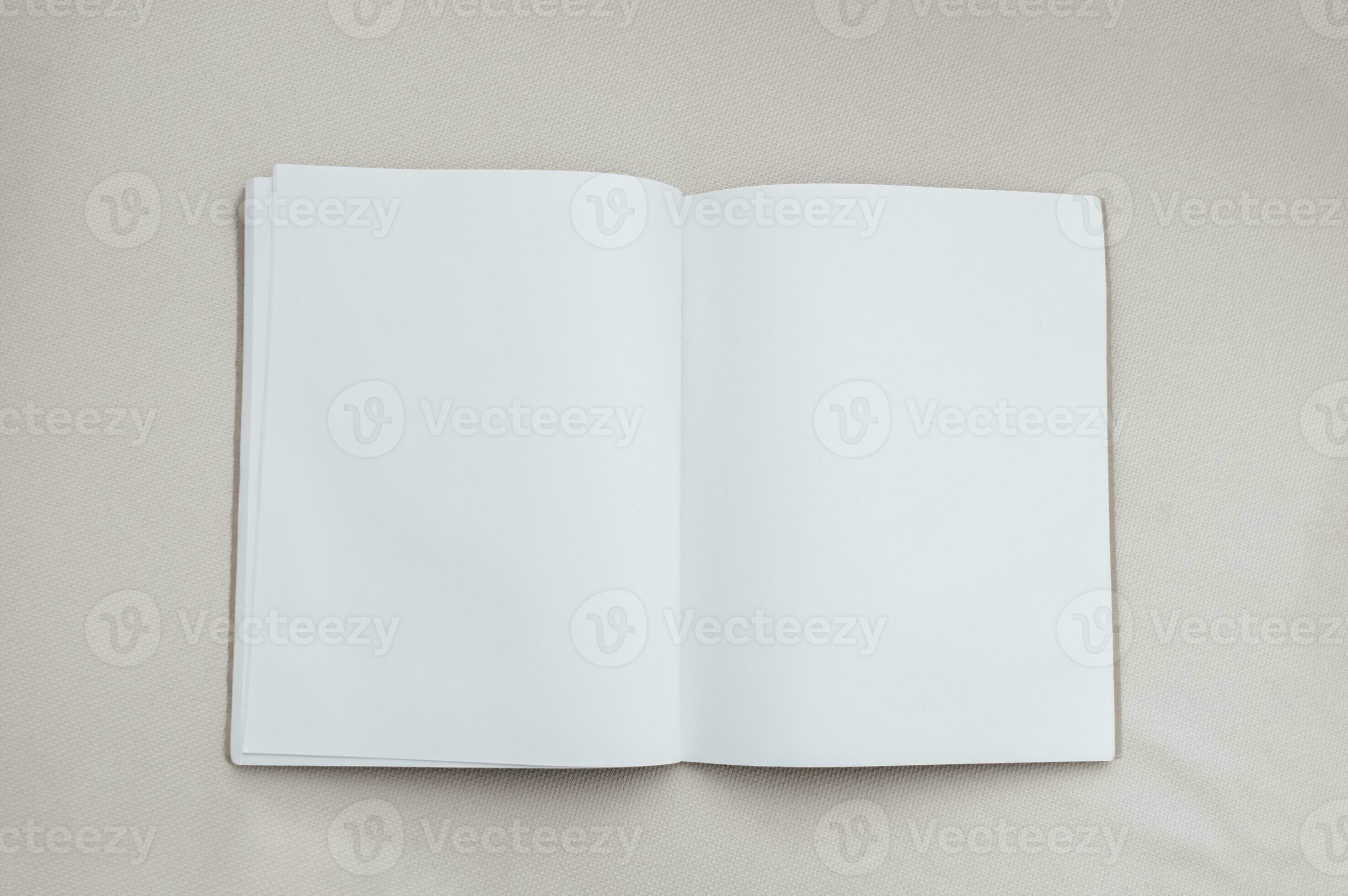 Mockup blank paper notebook and green leaf on a gray background