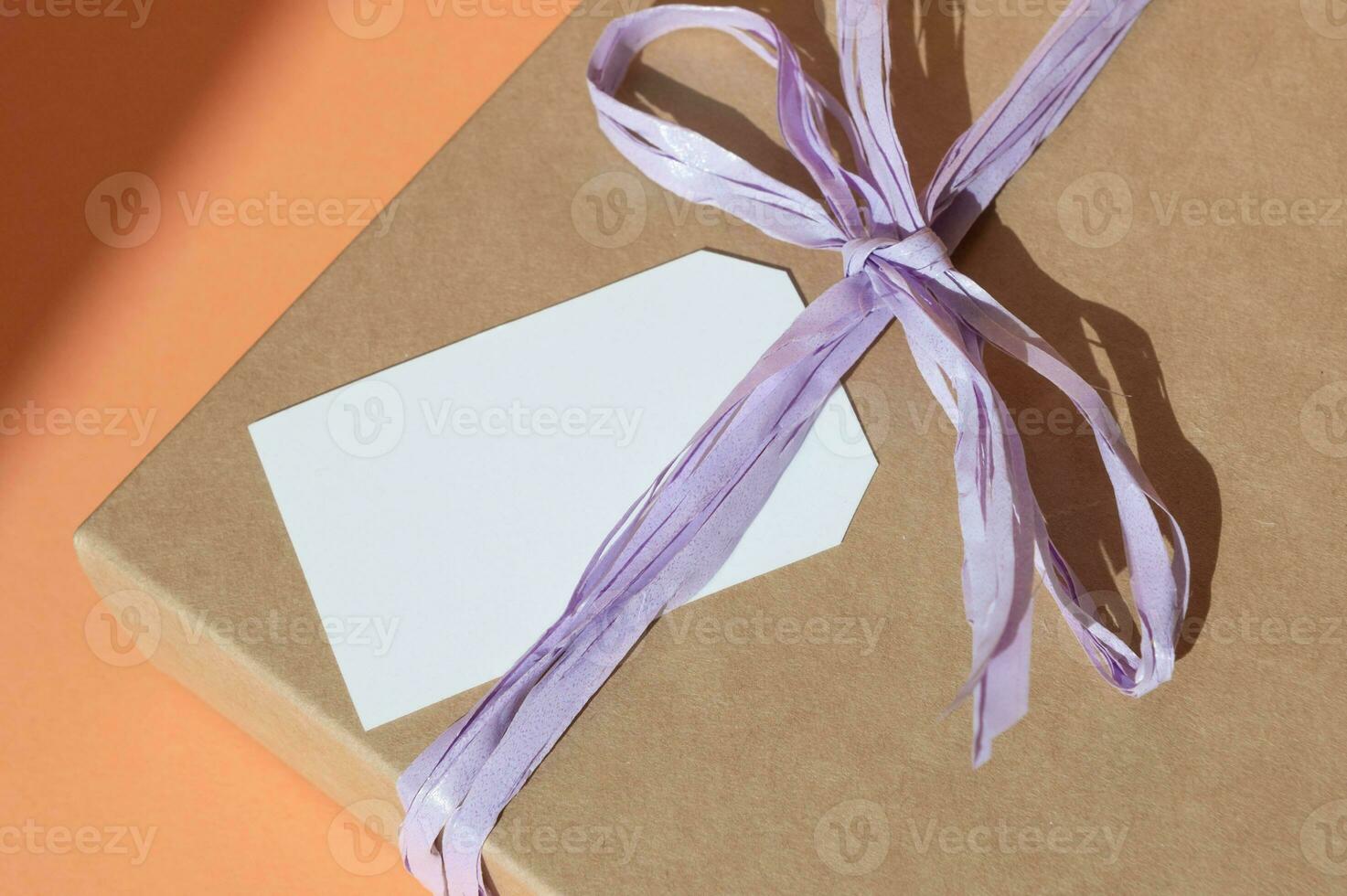 Boxes for parcels made of kraft paper on a gray background. Gift box with a tag for text, logo. A place for text, a ribbon with a bow on a gift box, a greeting card photo