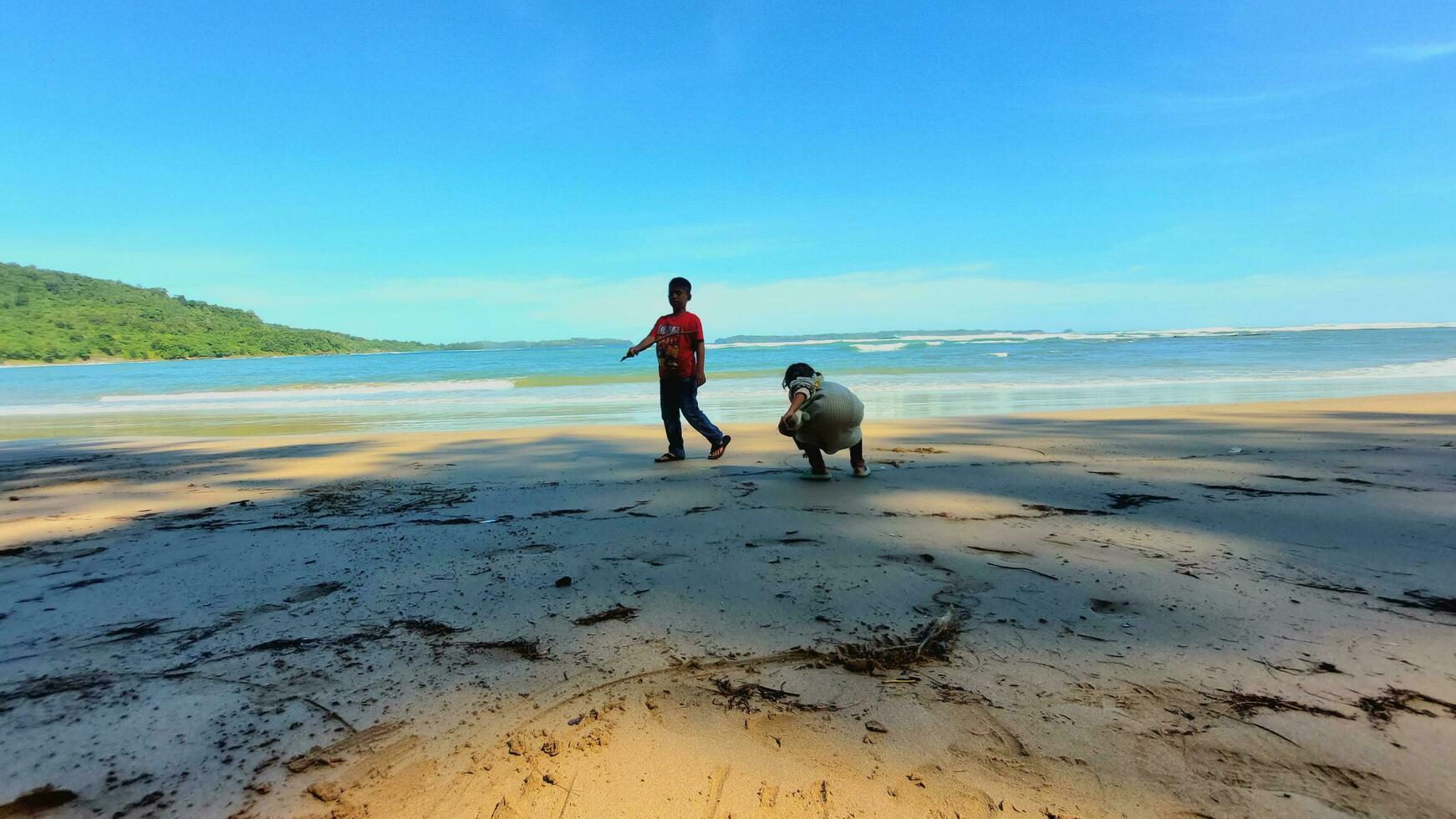 Aceh, Indonesia, July 7, 2023. two children playing, tourists on a sandy beach in the Black Sea on the beach in summer photo