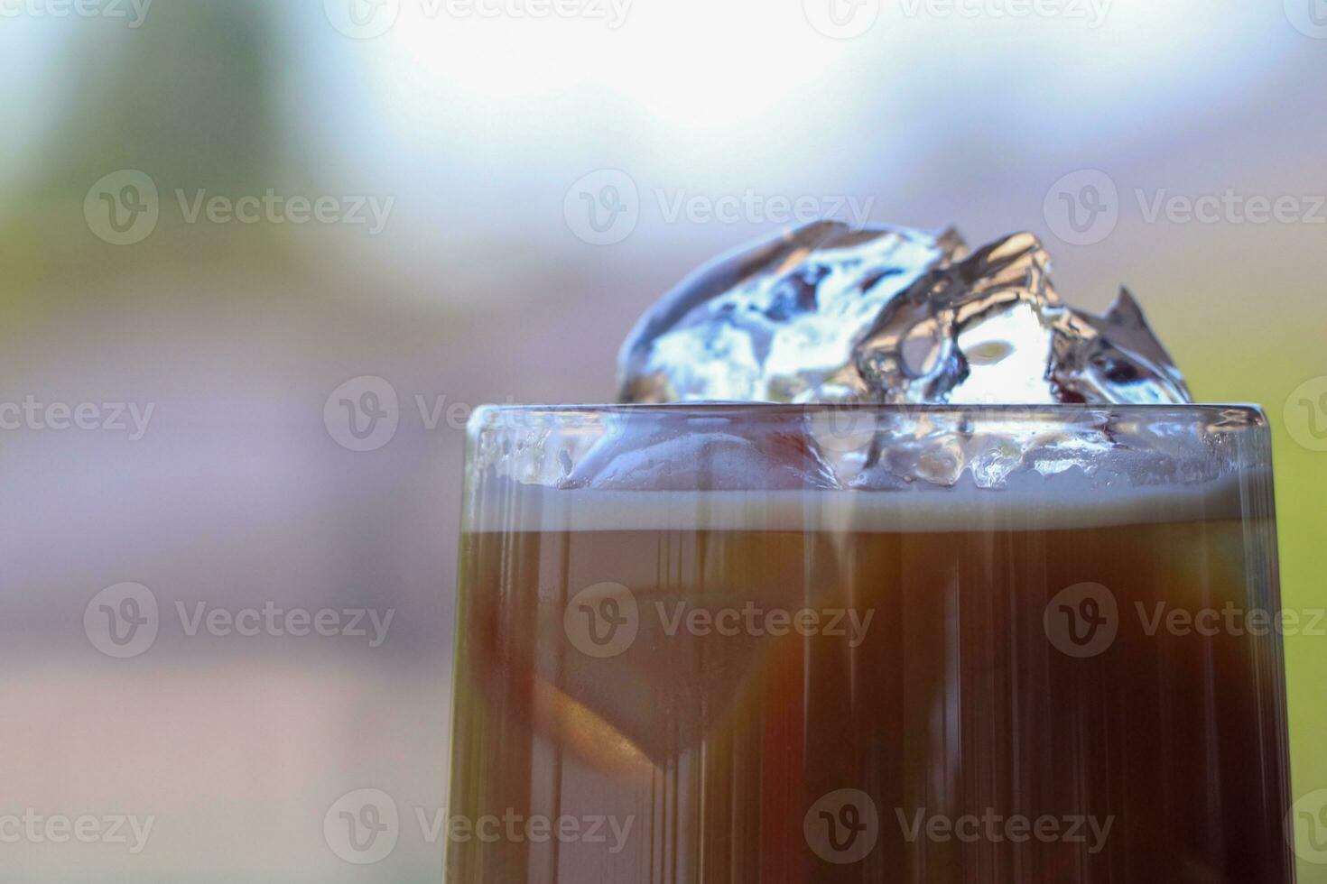 Iced coffee in glass cup or coffee latte on blurred background photo