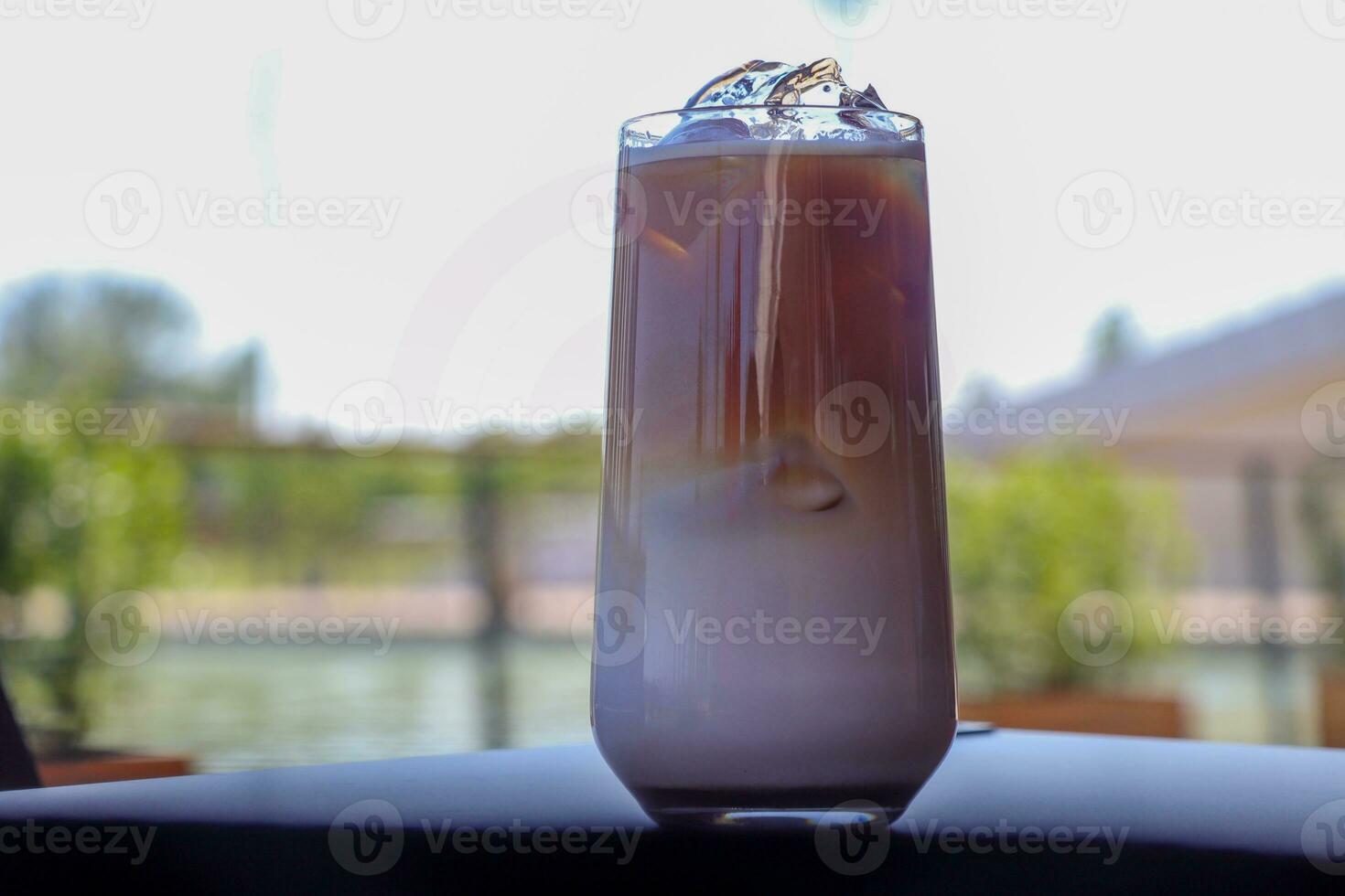 Iced coffee in glass cup or coffee latte on blurred background photo