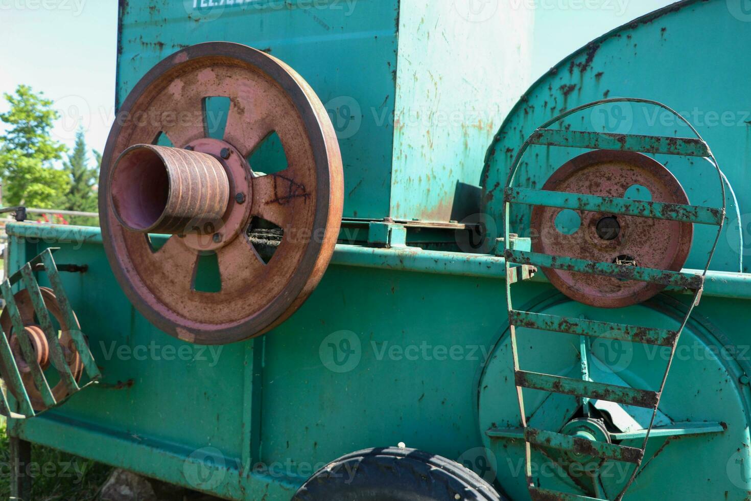 Old farm plow, Abandoned farm implement in the village, rusted machinery, sky, grass and garden, wheeled farming photo