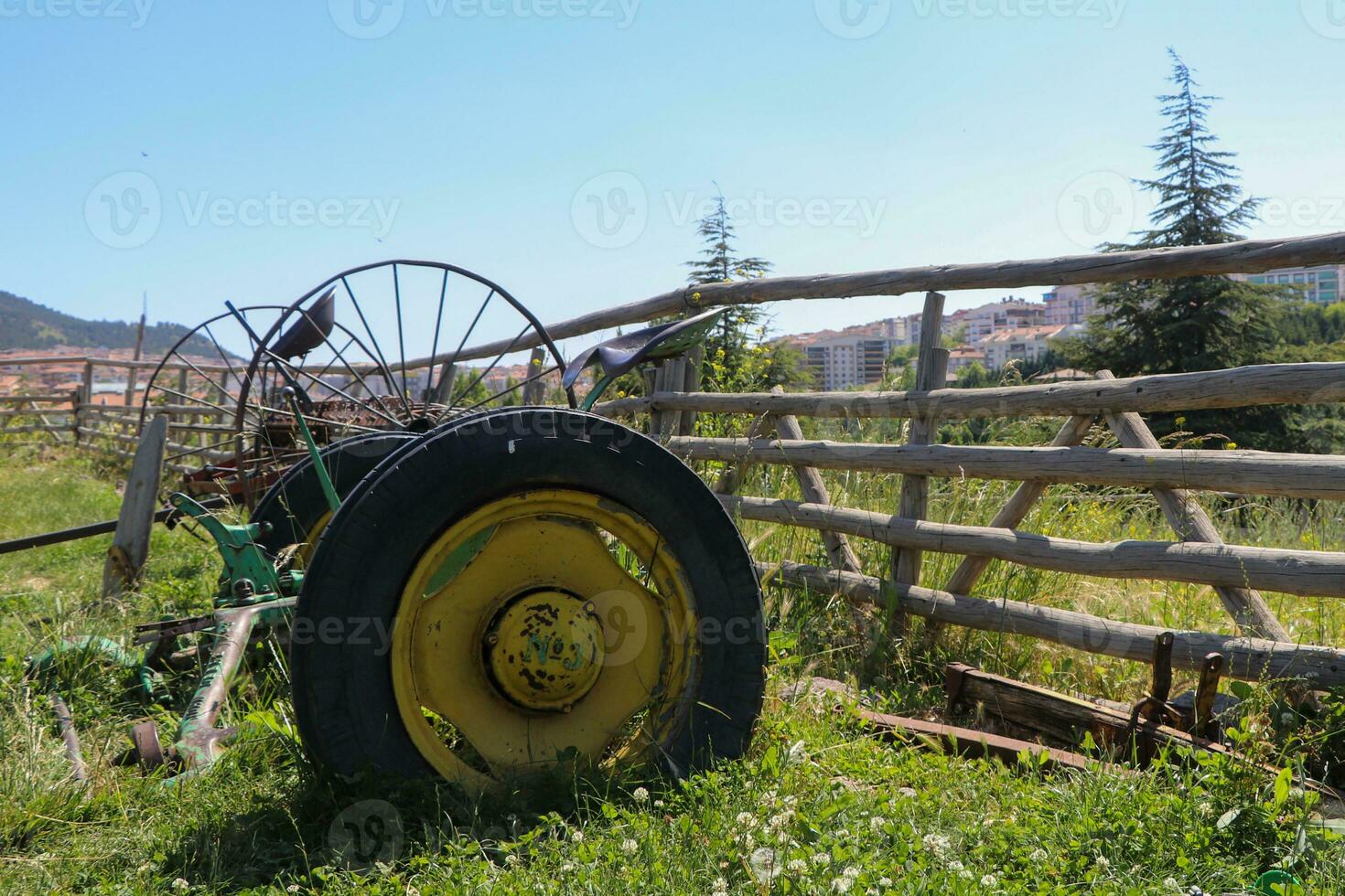 Old farm plow, Abandoned farm implement in the village, rusted machinery, sky, grass and garden, wheeled farming photo